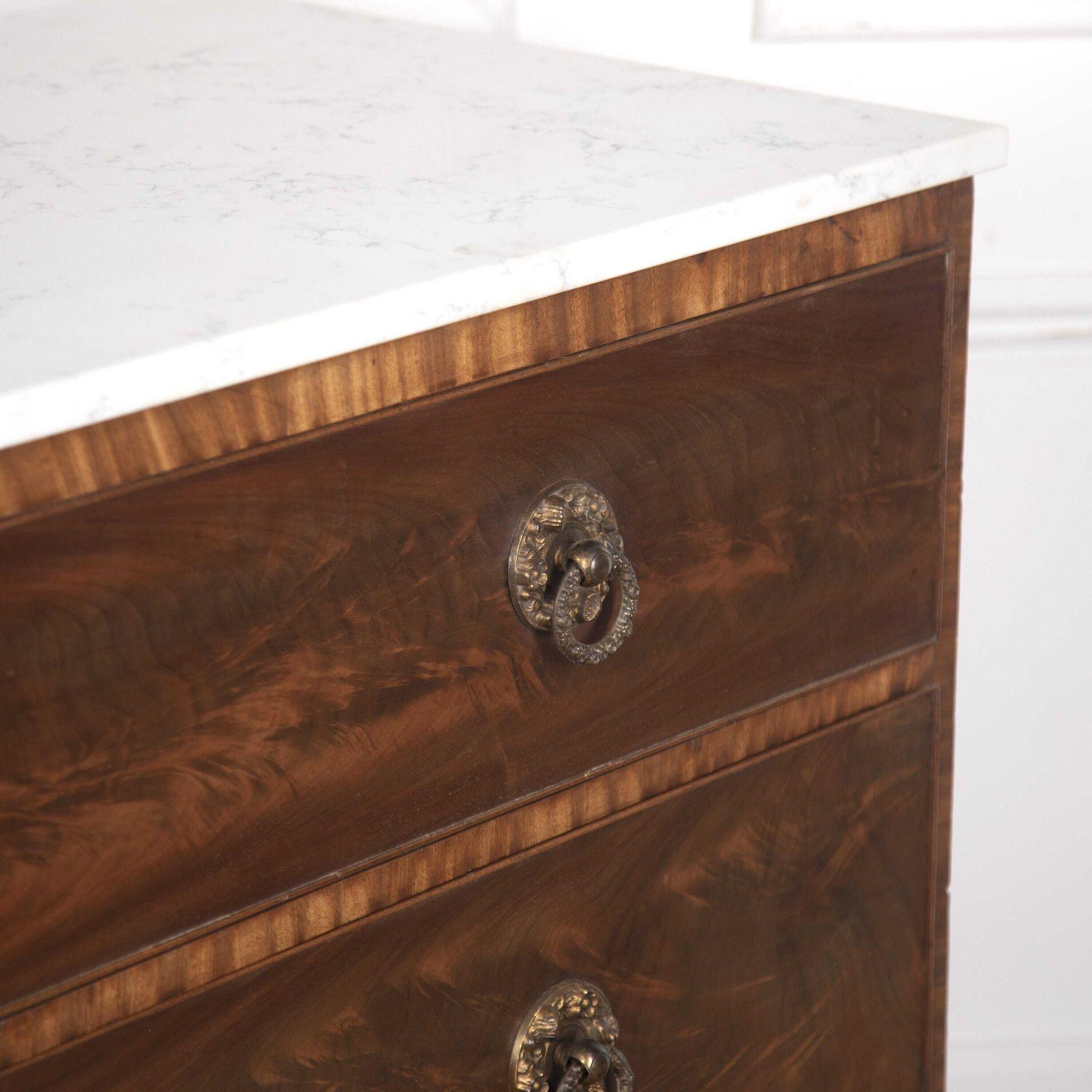 Impressive 19th century Flame mahogany commode.
This piece stands well, the three large drawers are decorated with flame mahogany with its original quality brass handles and ivory escutcheon inlay.
A replacement marble top finishes off this