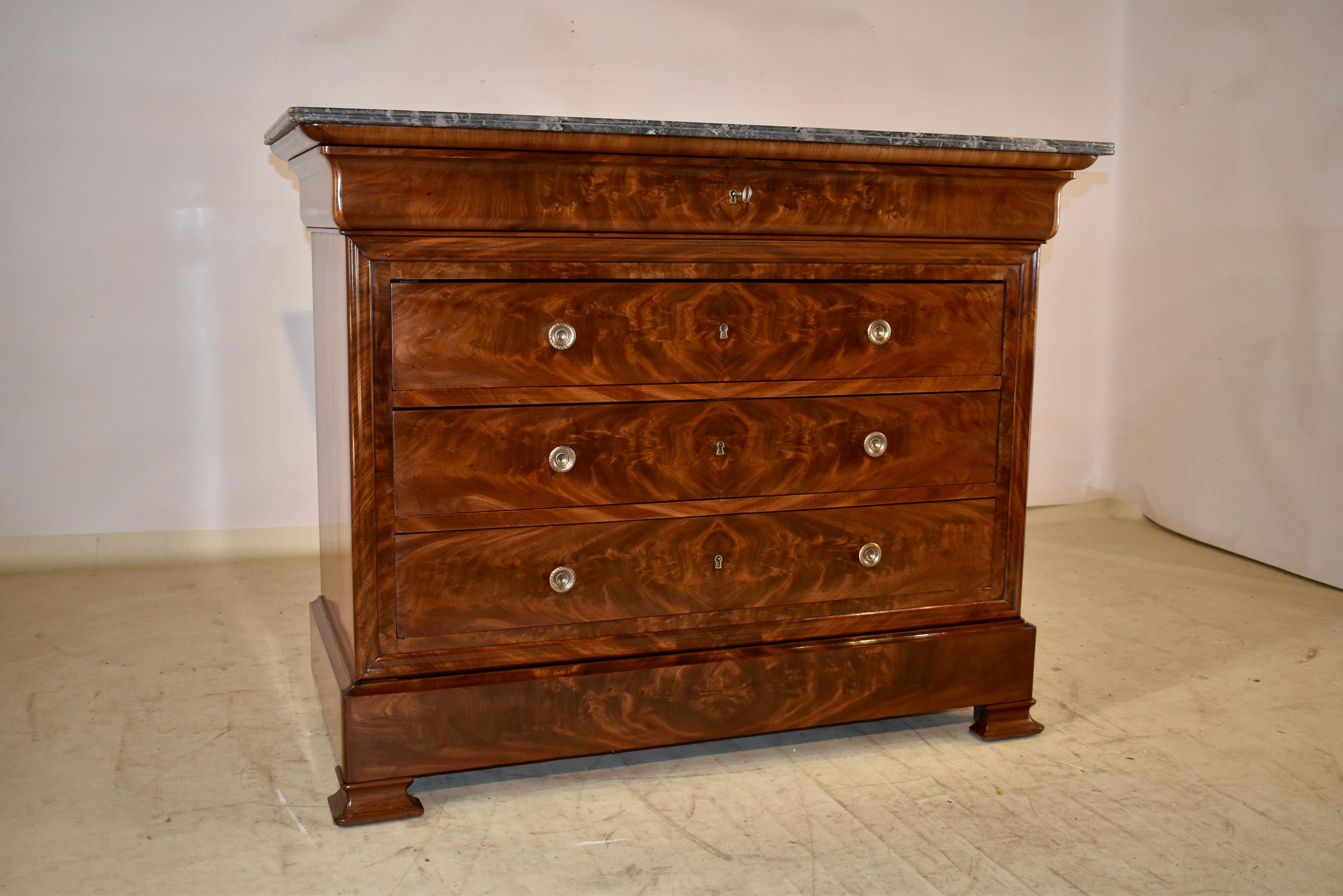 19th century commode from France made from Mahogany.  The top is made from exquisitely grained dark gray marble, sitting atop a mahogany case, which is fairly unusual in this type of piece.  The sides are simple and have the shaped molding at the