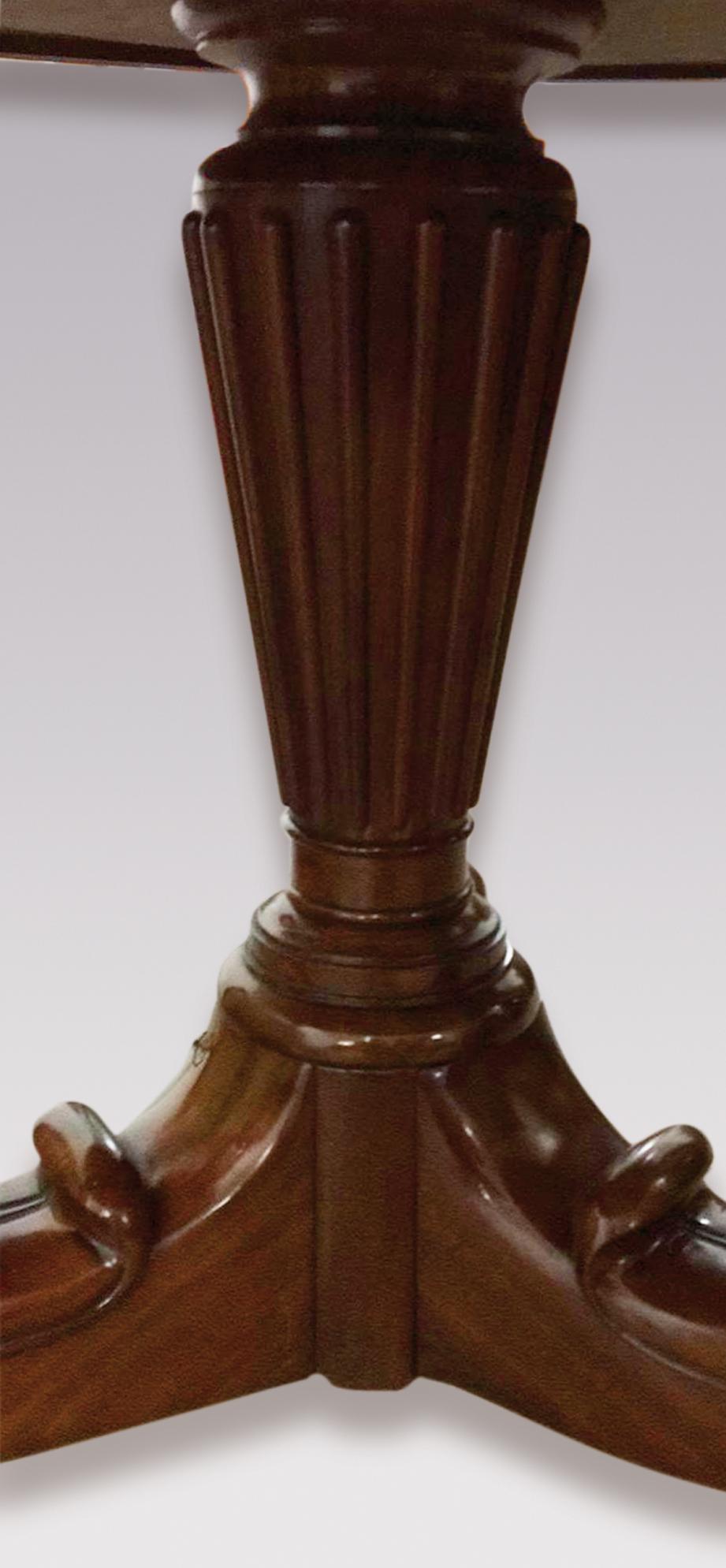 An early 19th century French mahogany gueridon table having circular moulded grey marble top raised on reeded turned tapering column and scrolled leaf-carved tripod base ending on boldly carved lion’s paw feet with castors.