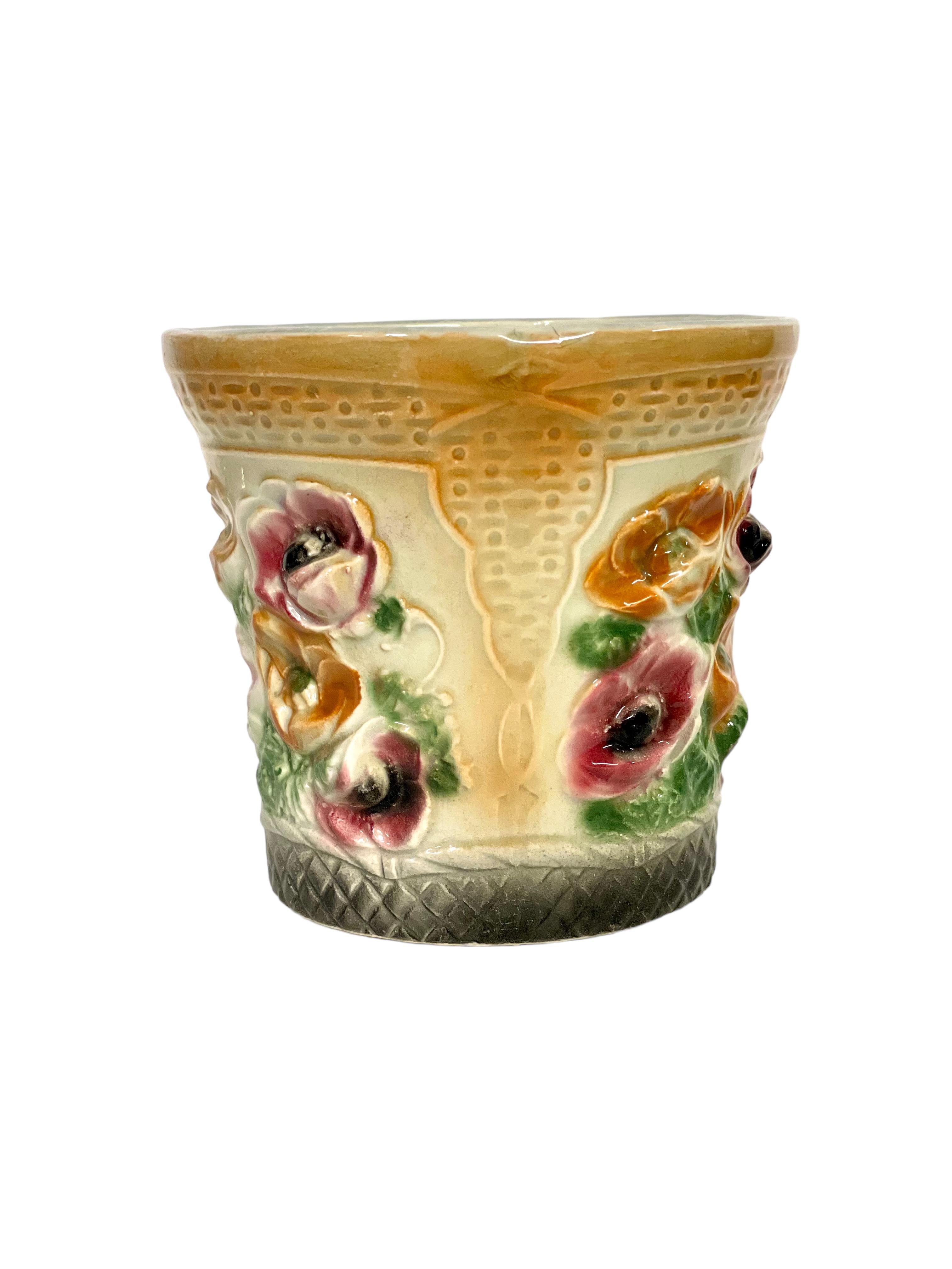 Cache-pot en majolique du XIXe siècle, très coloré, vivement décoré d'un motif envoûtant de coquelicots en fleurs et de feuillage, sur un fond jaune imprimé d'une texture complexe de vannerie. La faïence majolique est réputée pour ses couleurs