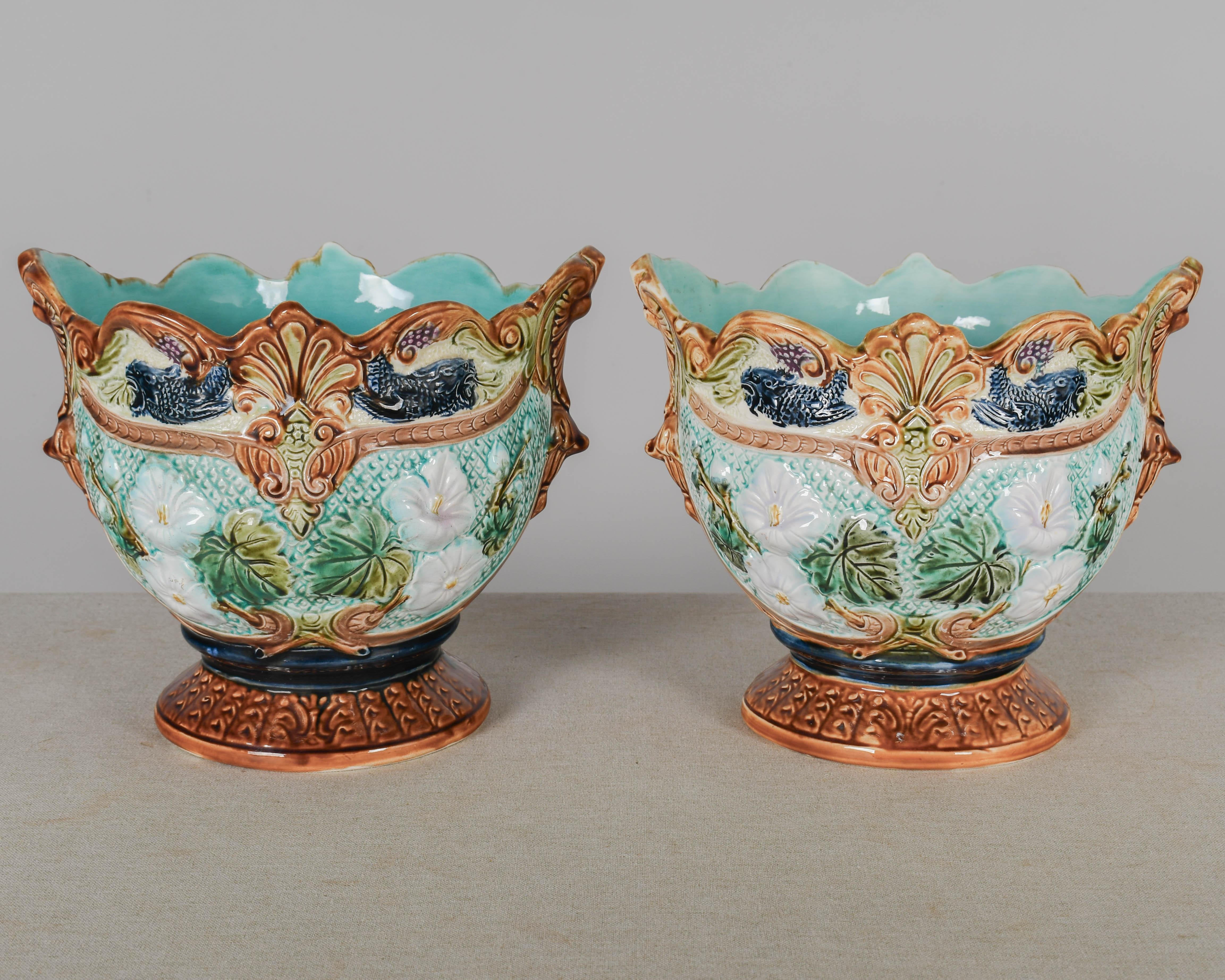 Coppia di vasi da cache in ceramica maiolicata francese del XIX secolo, decorati con begonie bianche nei toni del verde, turchese, blu e ocra. Interno smaltato in blu uovo di pettirosso. Non segnata, attribuita a Sarreguemines. Circa 1890-1899. 
11