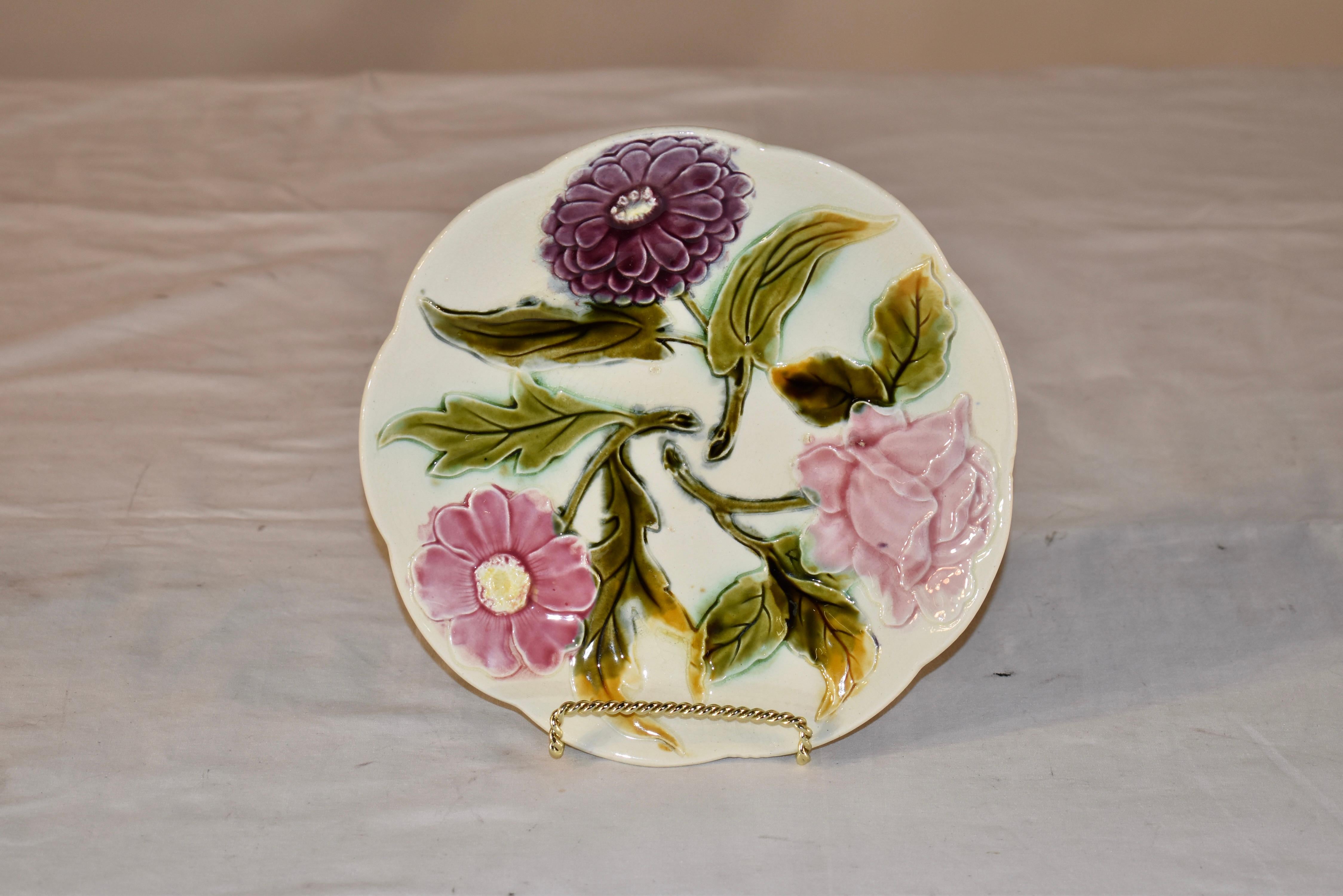 Majolikateller aus Frankreich aus dem 19. Jahrhundert mit einem Muster aus drei Blumen.  Der Hintergrund des Tellers ist elfenbeinfarben mit drei farbenfrohen Blumen.  Dies ist ein schöner Teller mit einem ungewöhnlichen Muster.  Es wäre perfekt für