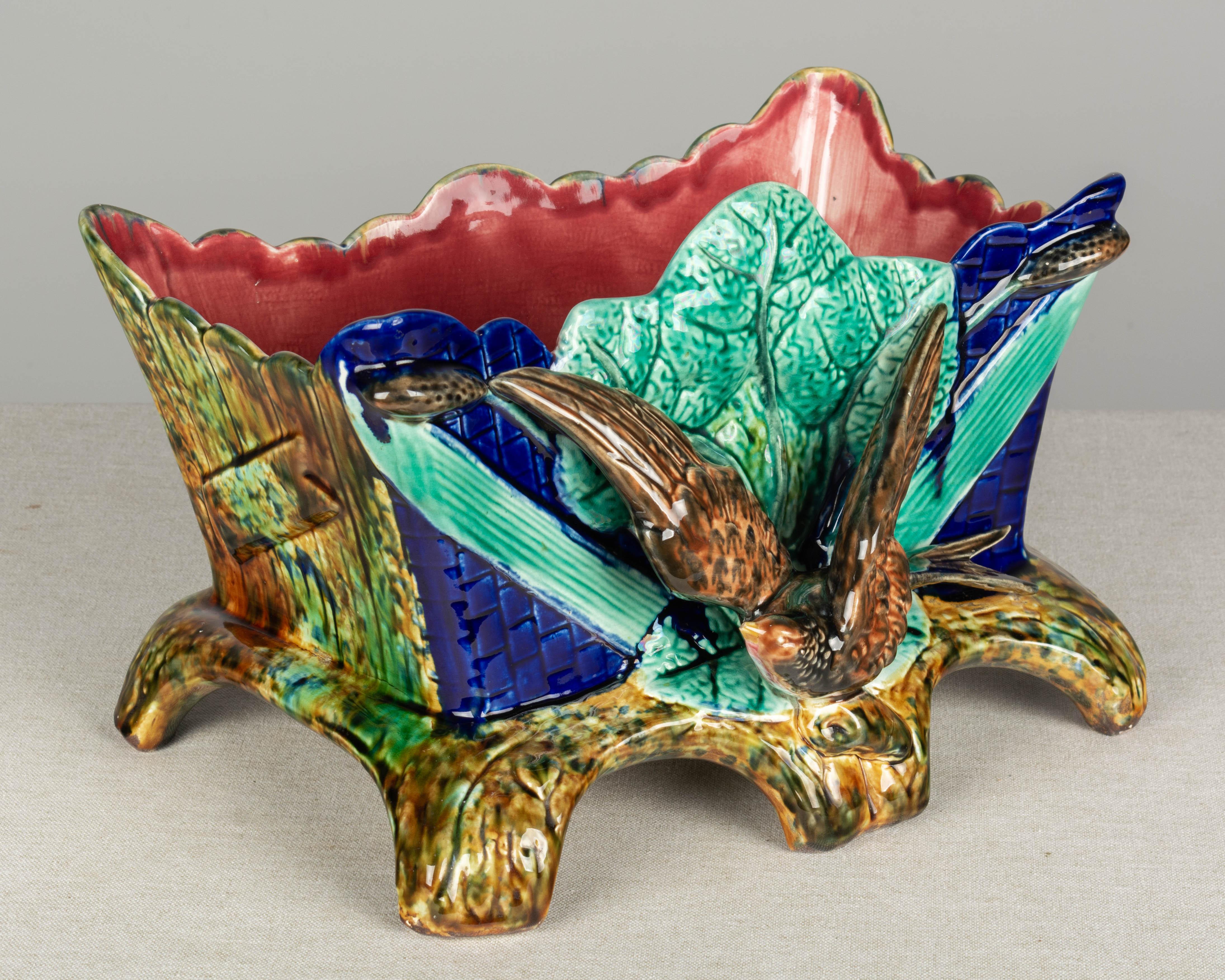 A 19th century French Majolica glazed ceramic jardinière, or planter, in the shape of a wood box decorated with a brown bird or pheasant with outstretched wings against green leaves on a deep cobalt blue ground. Vividly colored glaze in green,