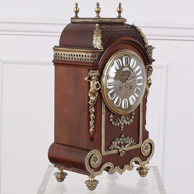 A French late 19th century mantel clock, the case of carved mahogany accented with ormolu mounts. A French label inside the back traces its history through a French family, starting with its gift as a wedding present in 1886.