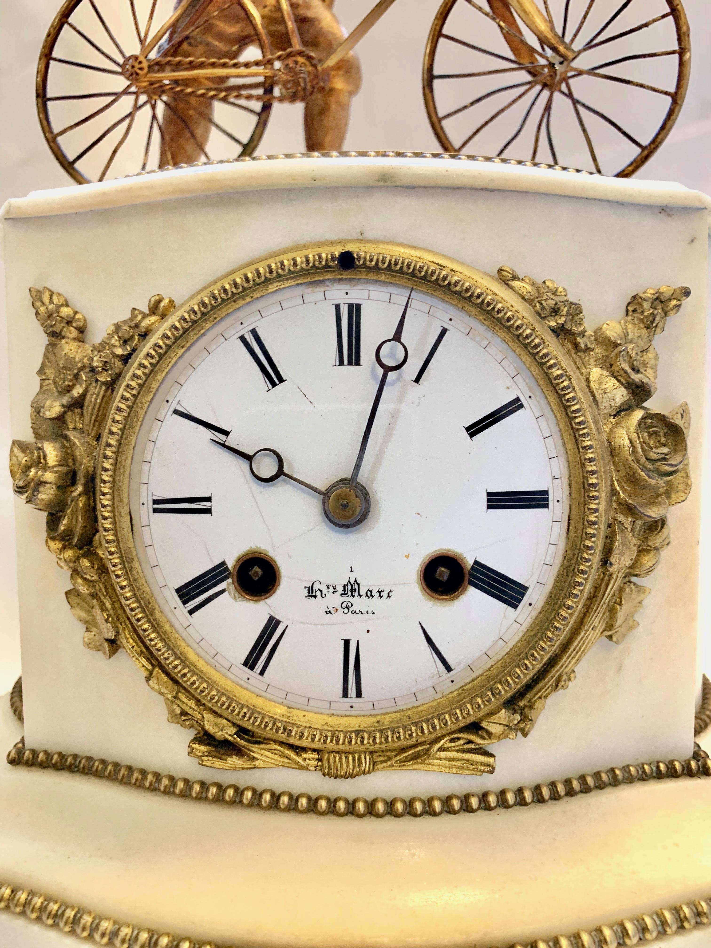 A French marble and bronze antique clock with man and bicycle also in bronze. Signed 'Henry Marc a Paris' on the white enamel dial with Roman numerals. This lovely piece has two winding holes in the dial and strikes on a bell.
 
 