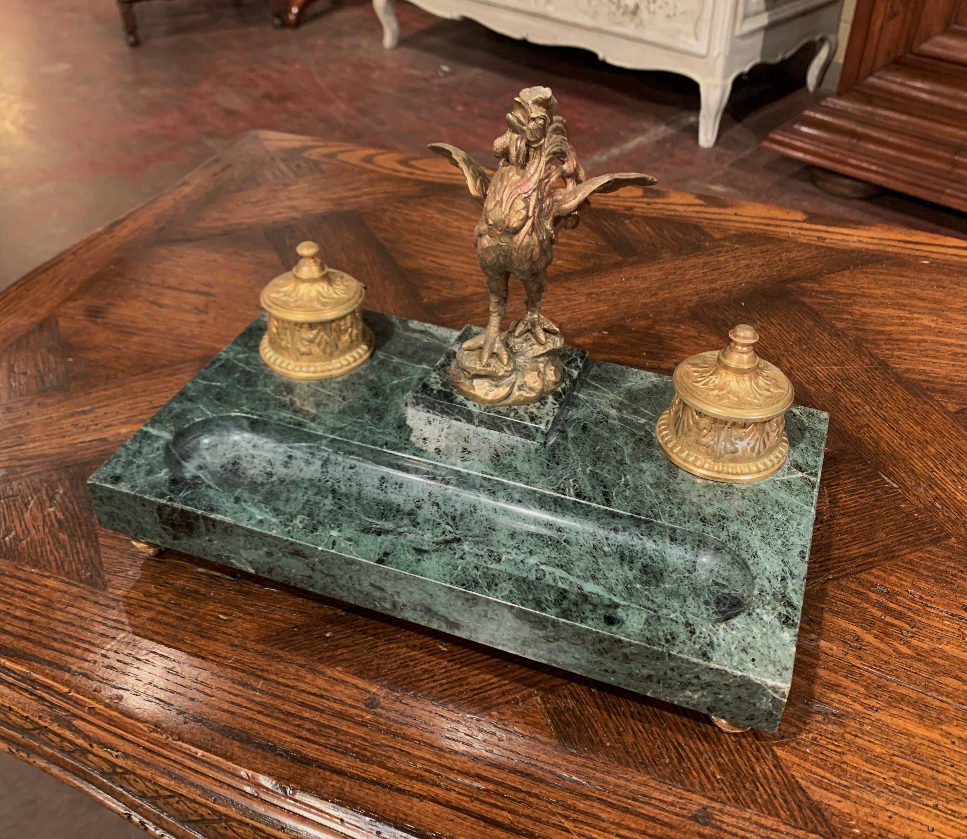 Decorate your desk or study with this elegant antique inkwell, crafted in France, circa 1880, and situated on a rectangular green marble base, the desk accessory features a bronze rooster standing on a small square base. The bird figure with