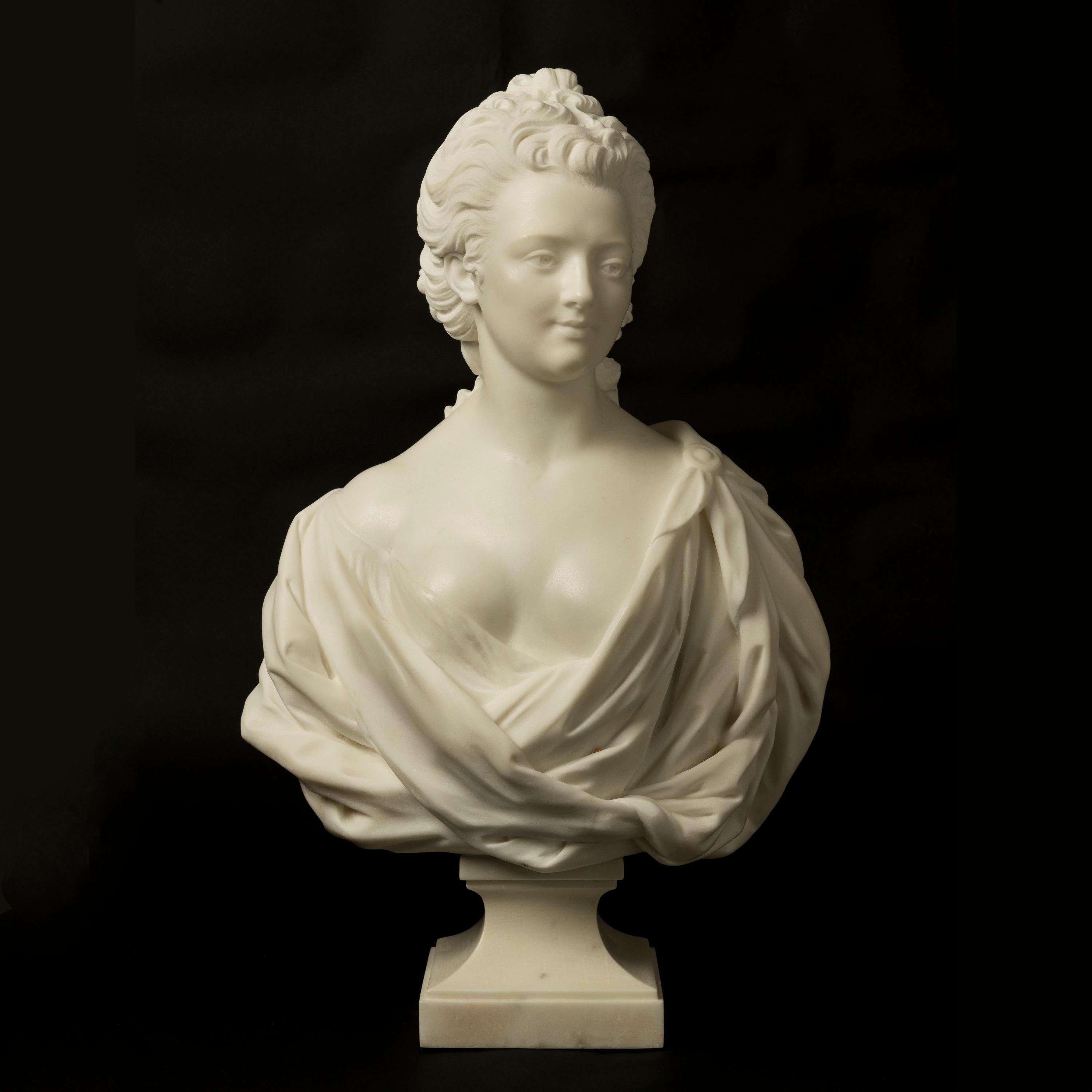 A Marble Bust of a Classical Maiden

Carved from statuary marble, the female bust of a coiffed lady with ribbon-tied hair flowing down her back where it joins her voluptuous dress with billowing folds.
French, circa 1880