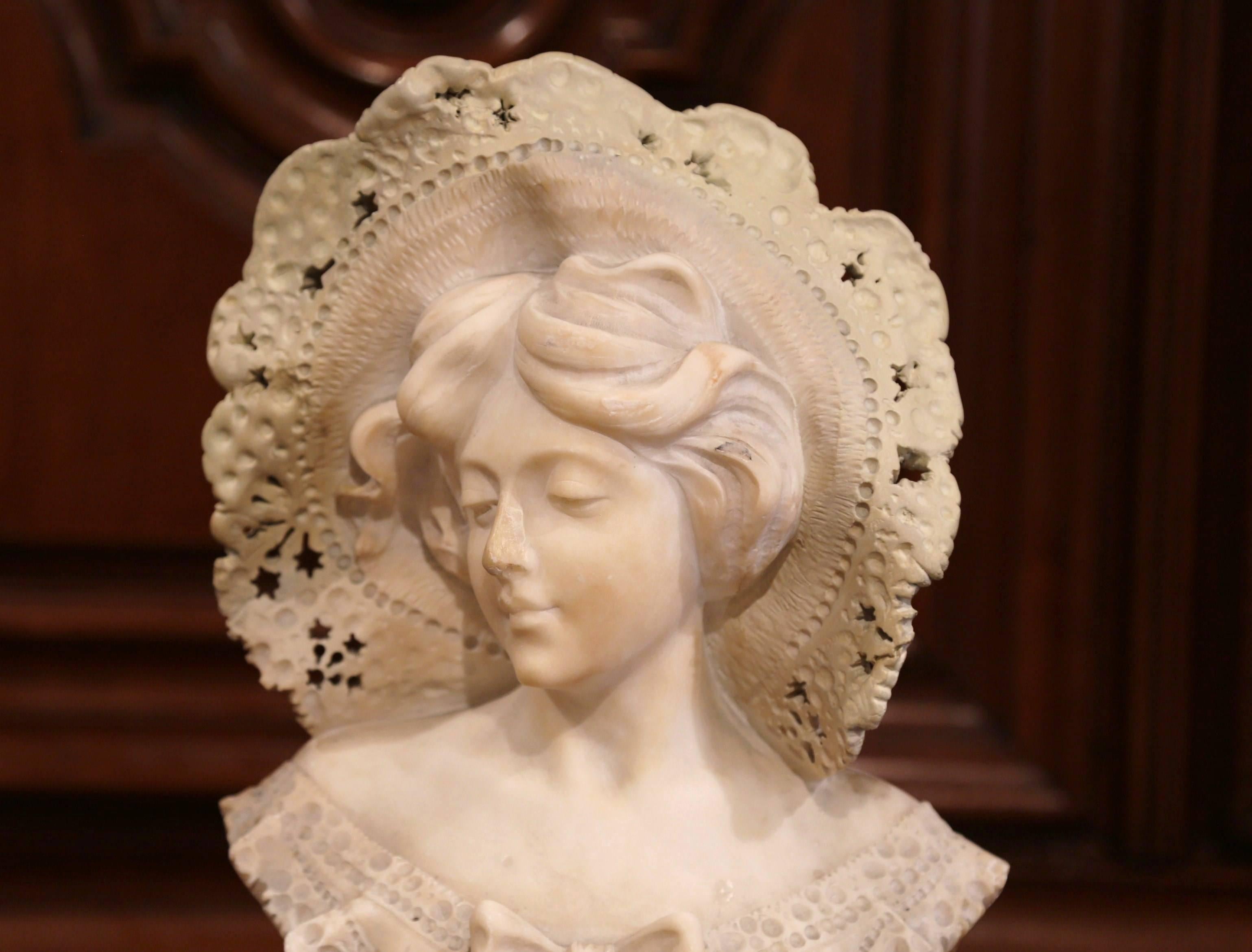 This tall, antique bust is the perfect addition to any elegant room. Sculpted in France, circa 1880, the marble piece sits on a round swivel base and features the face of a young female beauty, with beautifully sculptured lace work on hat and dress