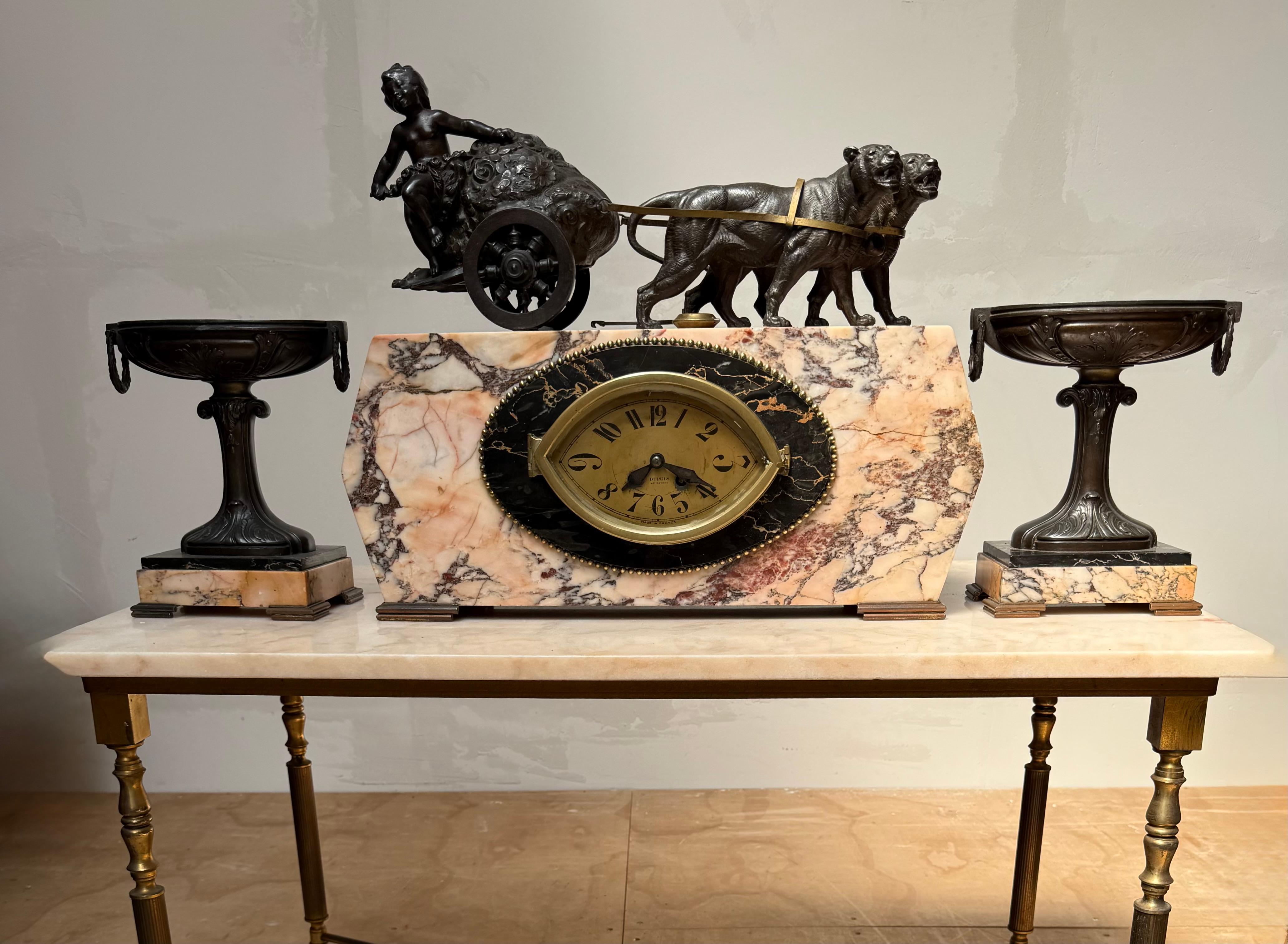 Poetic power: French garniture clock with panther-drawn floral chariot.

A magnificent late 19th-century French garniture clock set that captures the poetic elegance of the Belle Époque era. Atop a richly veined Breccia marble base, a joyful putto