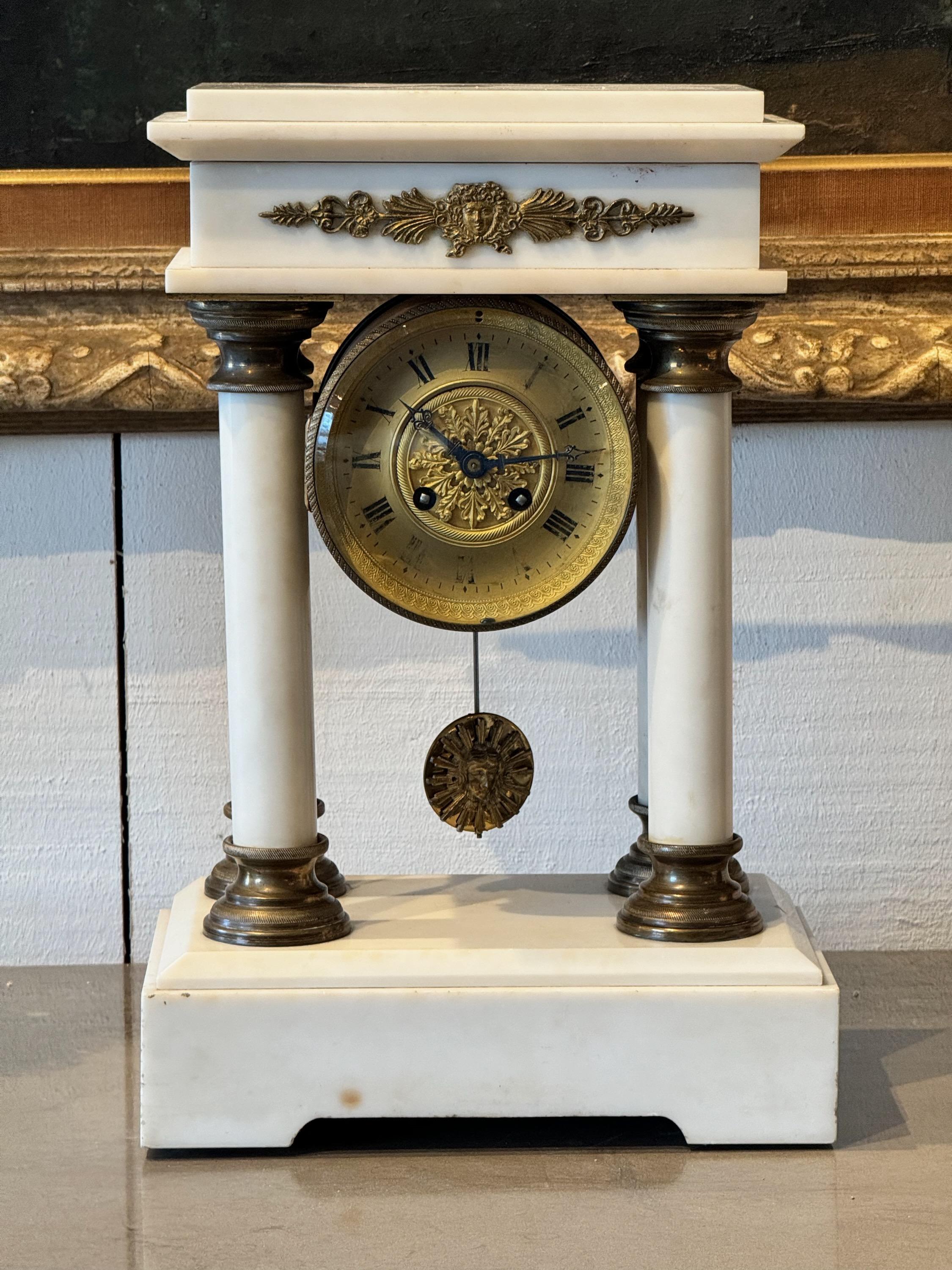A stately French Empire mantle clock. In marble with bronze mounts