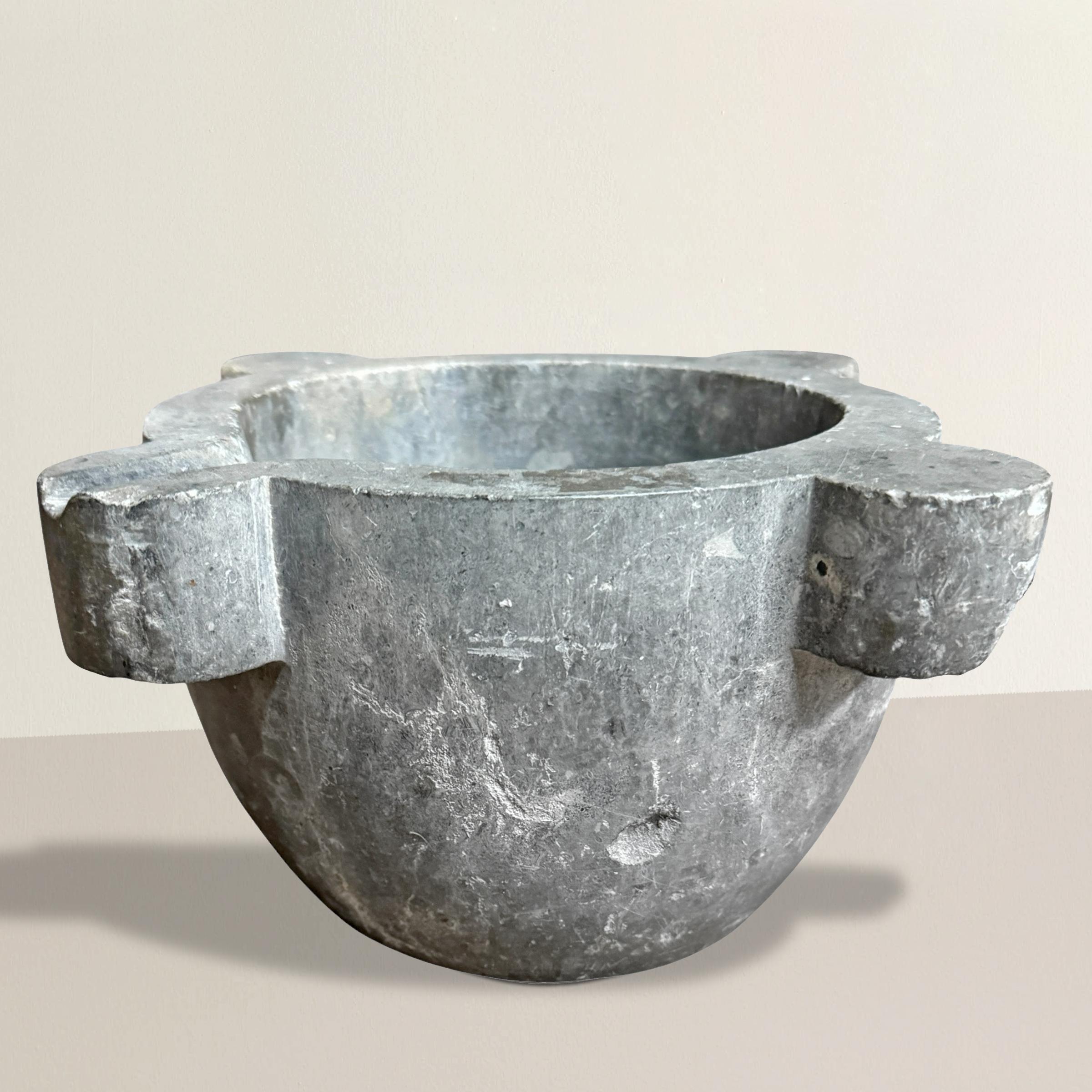 Un mortaio in marmo intagliato francese del XIX secolo, ricco di storia e ammorbidito da secoli di utilizzo, con la superficie levigata da una patina che solo 250 anni di tradizione culinaria potrebbero impartire. Un tempo strumento essenziale nella