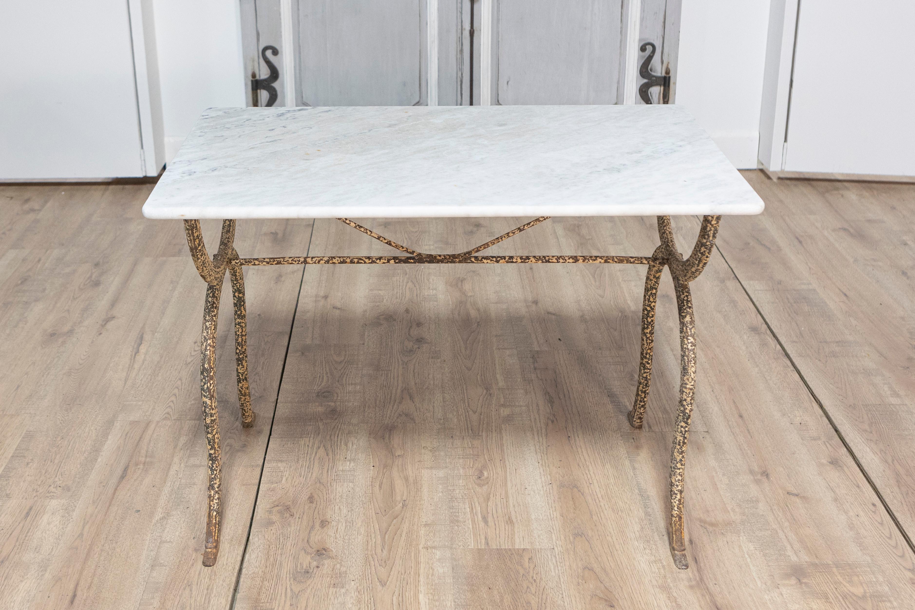 Cette élégante table de bistrot française du XIXe siècle allie un design intemporel à une sophistication fonctionnelle. Dotée d'un plateau en marbre de Carrare magnifiquement vieilli, la table respire le raffinement avec sa surface lisse et