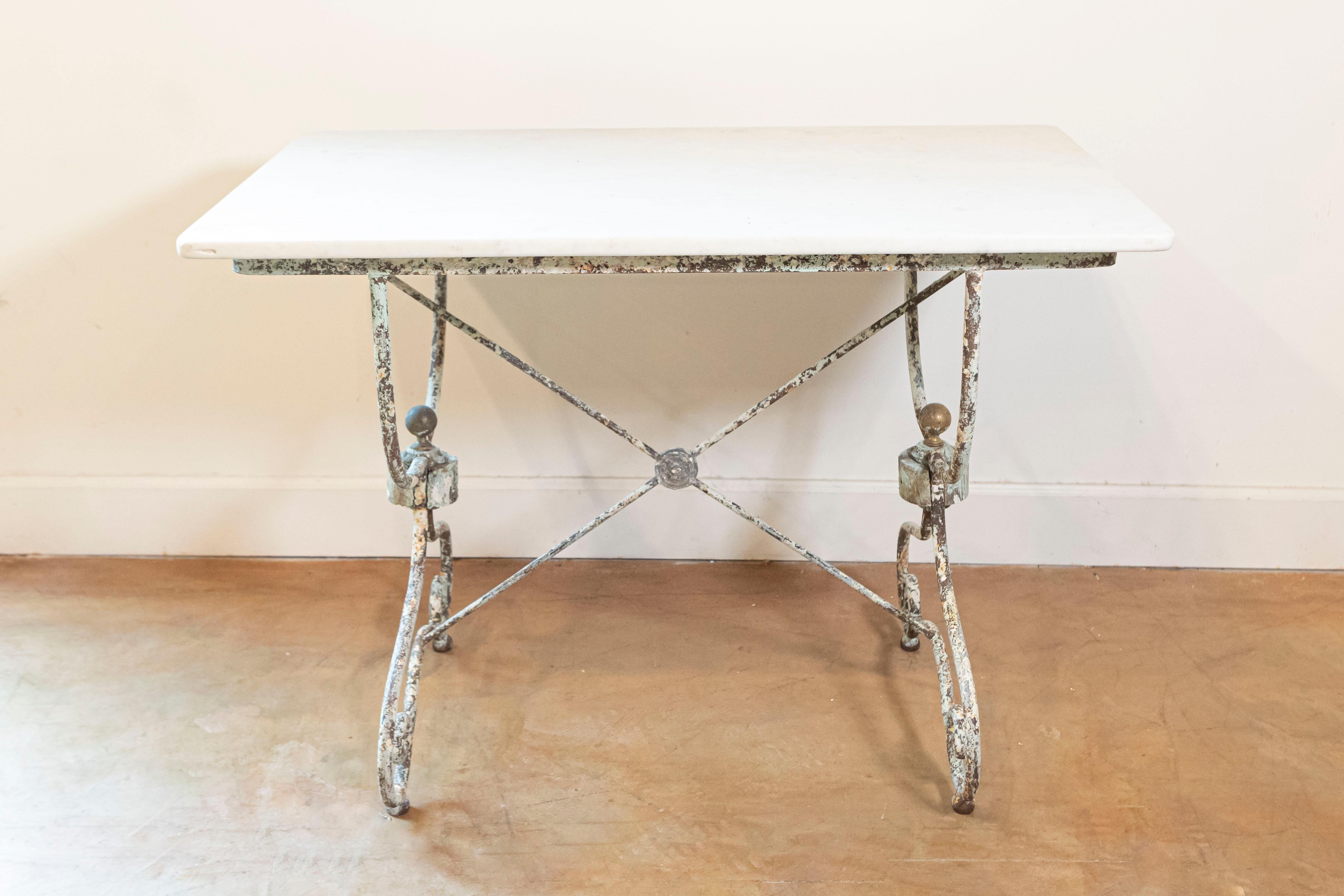 This 19th Century French marble top bistro table is a charming example of classic French café furniture, exuding rustic elegance and a sense of history. The table features a rectangular marble top, which is characteristic of the era.  The surface of