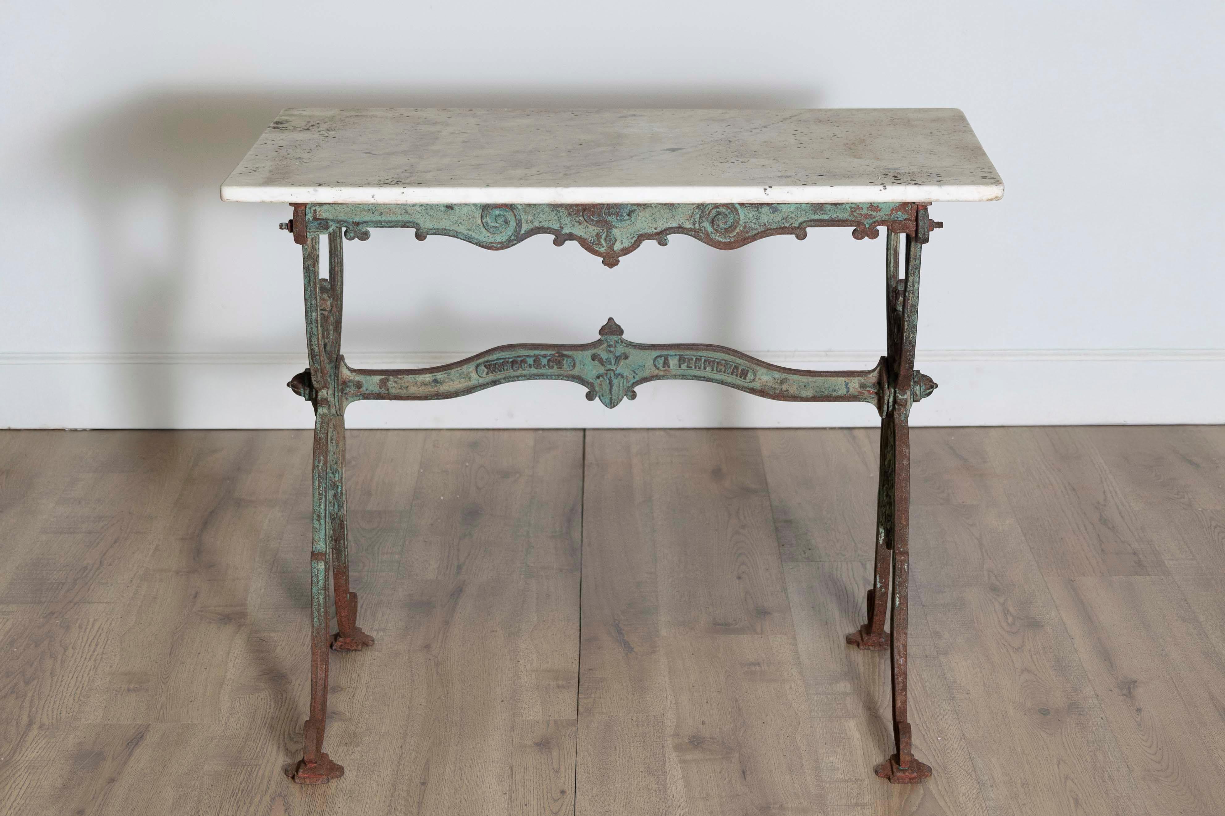 Cette table de bistrot française à plateau de marbre du XIXe siècle est un exemple frappant de savoir-faire artisanal et de conception fonctionnelle. Le plateau rectangulaire, en marbre blanc, présente une surface lisse aux veinures subtiles,