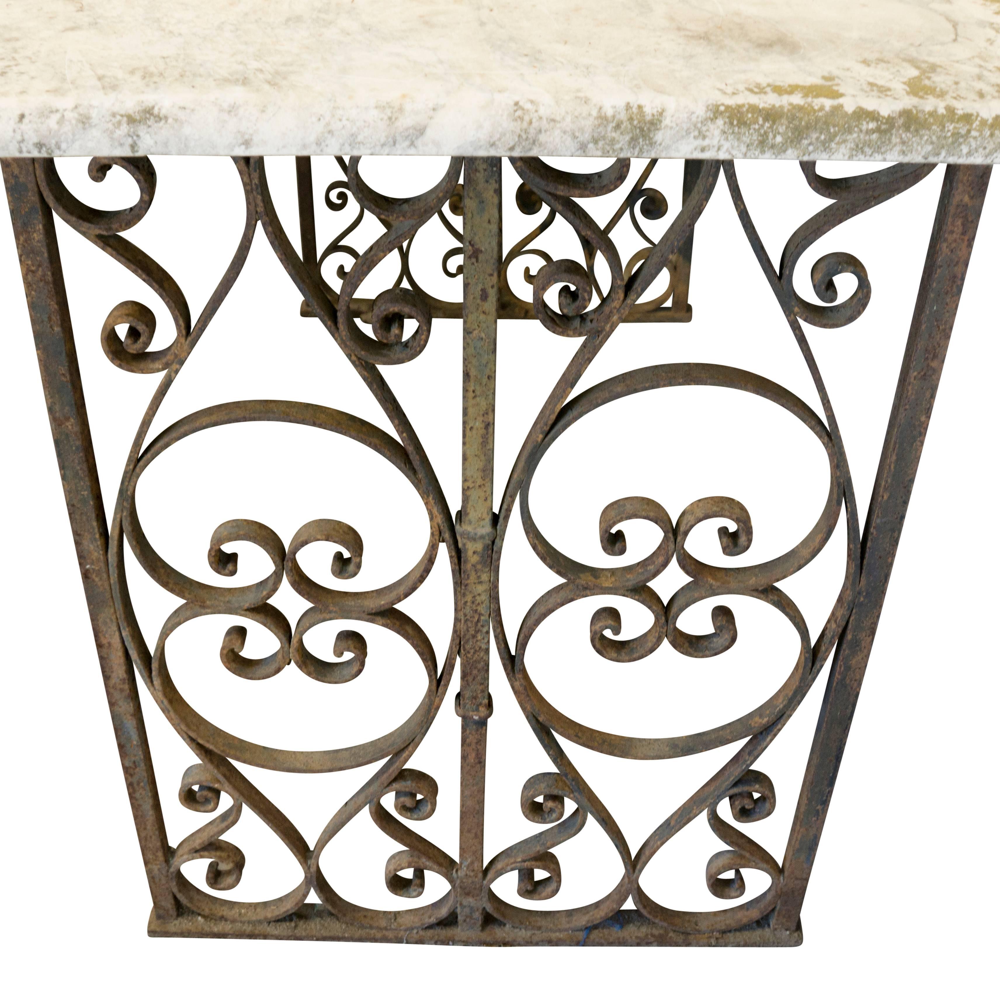 Talented iron work seen in the ten curling heart shapes found on this console table. The original 19th century marble top has a natural moss patina.