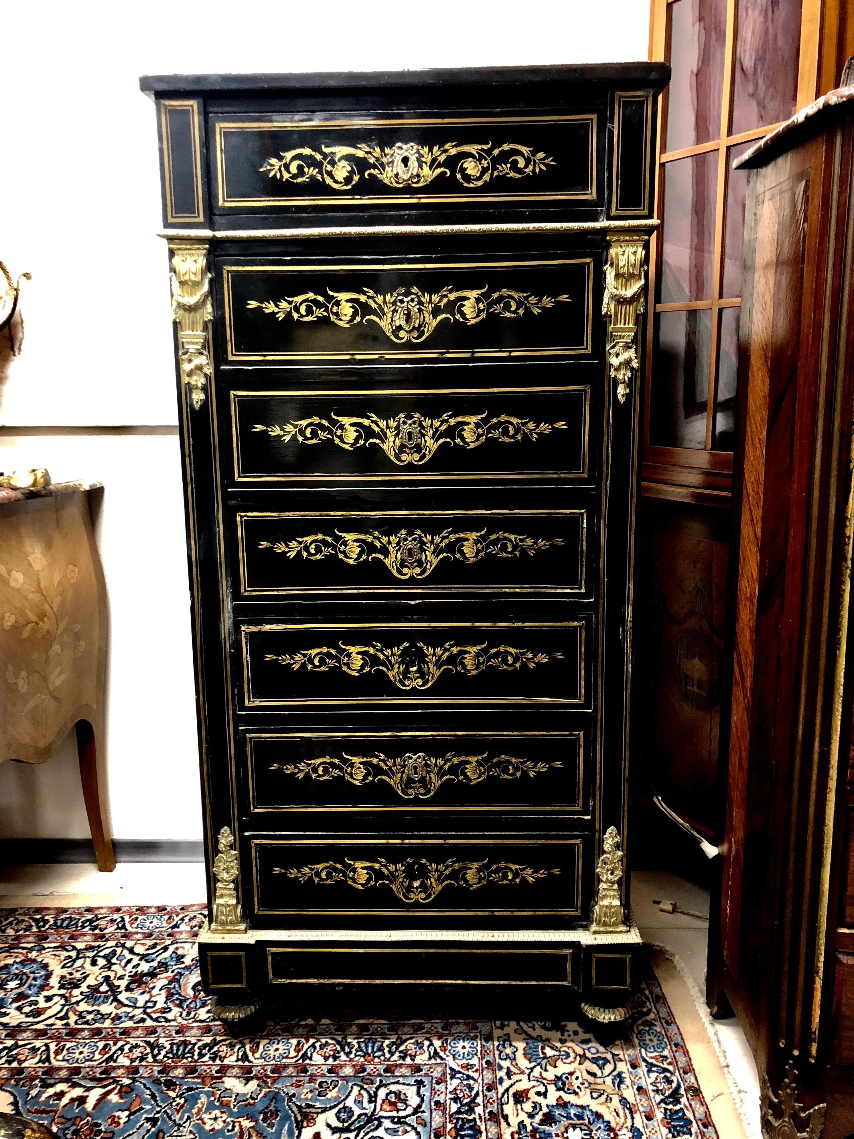 Lady's secretaire of blackened wood and nets decorated with rosettes and scrolls in gilded brass. It opens on the front with a drawer and a flap discovering niches and small drawers and three drawers in the lower part. White marble top surrounded in