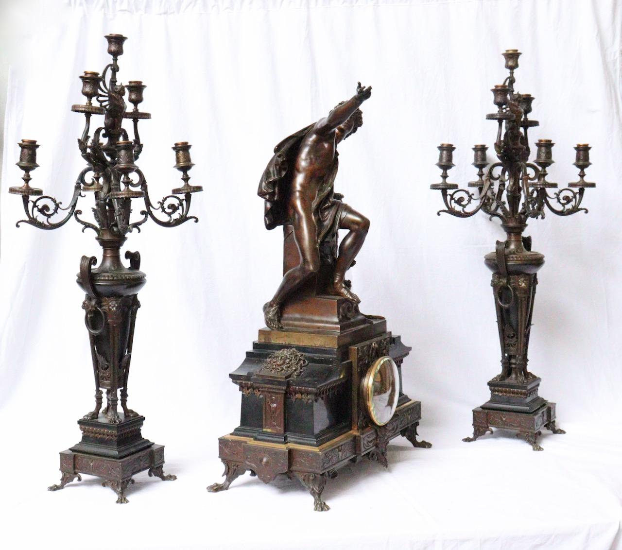 An Impressive 19th century French Marnyhac & Cie and Mathurin Moreau Three-pieces clock garniture

The Mantelpiece with APOLLON resting on the sacrificial tripod of the Pythia of Delphi in brown and gilt and black marble, the clock with central