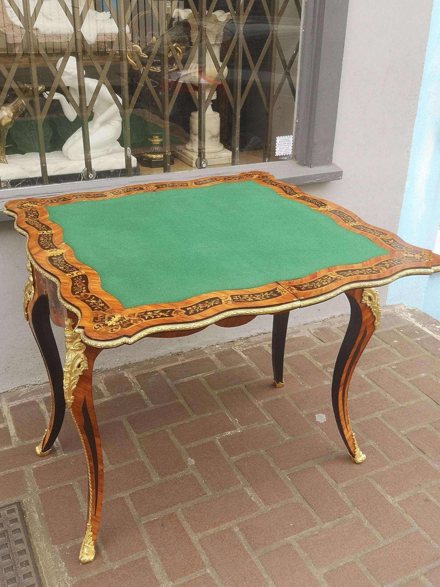 A fantastic quality 19th century French Kingwood card table, covered in marquetry of various woods, showing birds, flowers and a musical instrument. The top opens to reveal a green baize for cards which is bordered with more marquetry. Cabriole legs