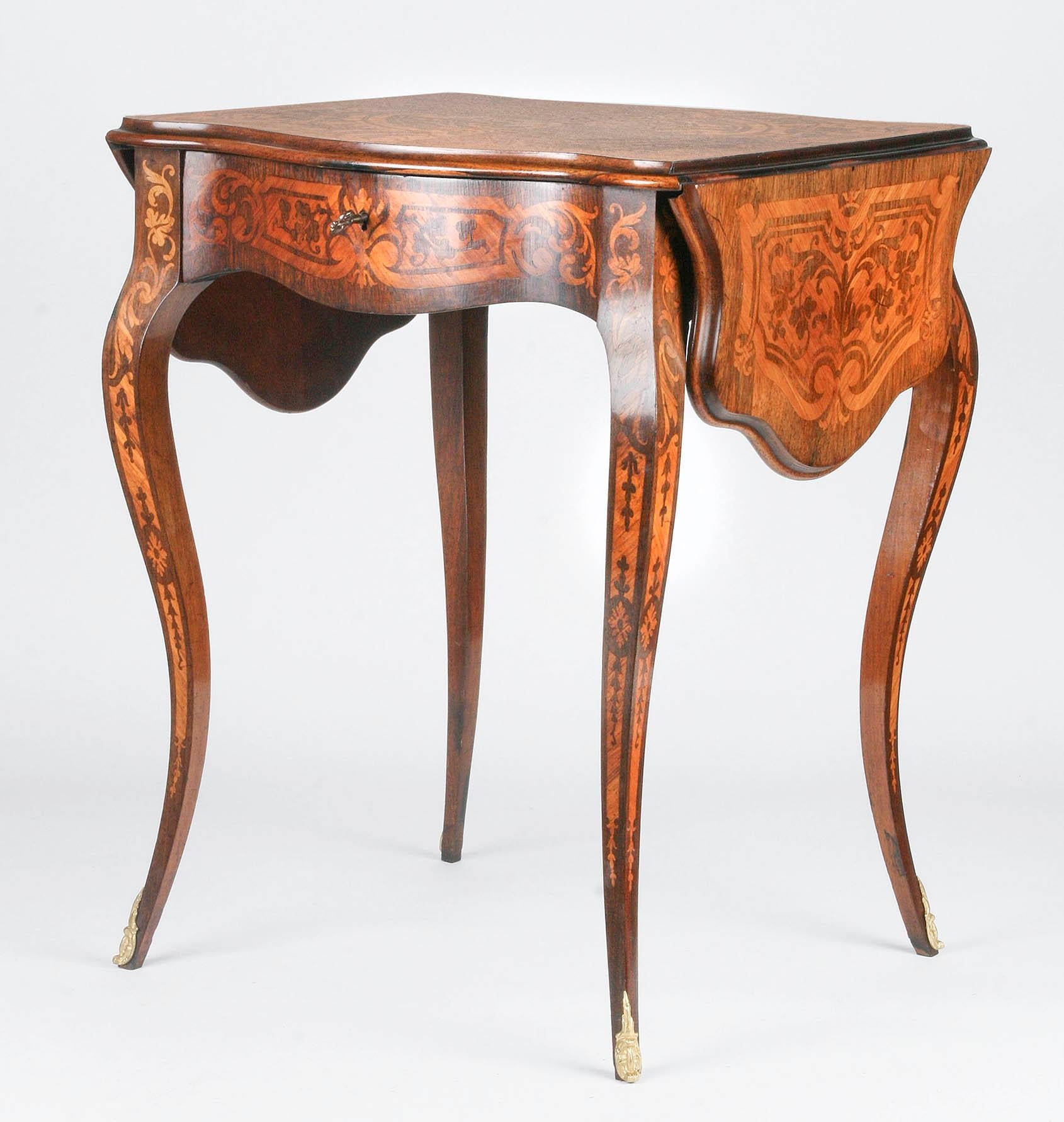 Charming drop-leaf table with symmetrical marquetry inlay.
The table has a drawer with key.
The top has a profiled edge, and the legs are finished with bronze gold-colored ornaments.
The whole is in very nice condition.

Measures: Width fold in 59