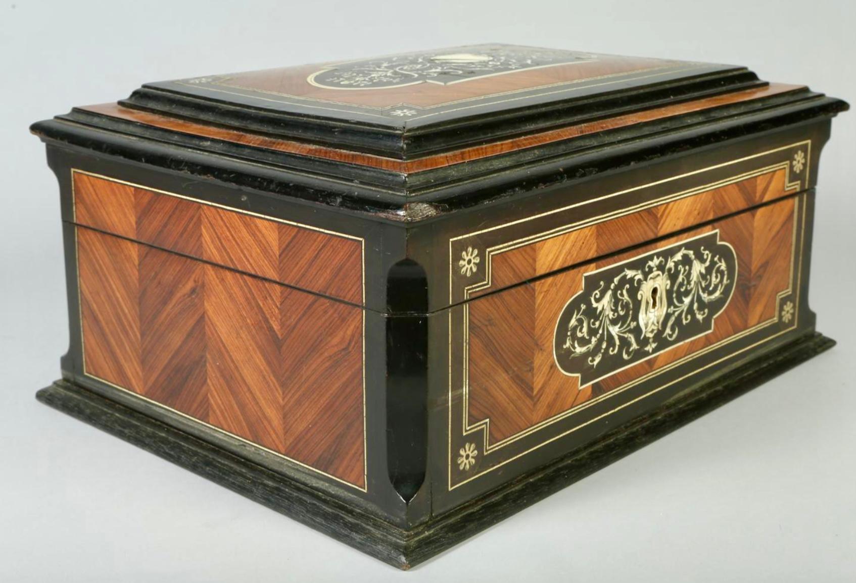 19th Century Napoleon III precious wood and marquetry Inlaid and ebonized box. Hinged box top features a central motif of fauna and flowers. Inner box is lined with blue satin padded upholstery with original blue satin buttons. Would make a great