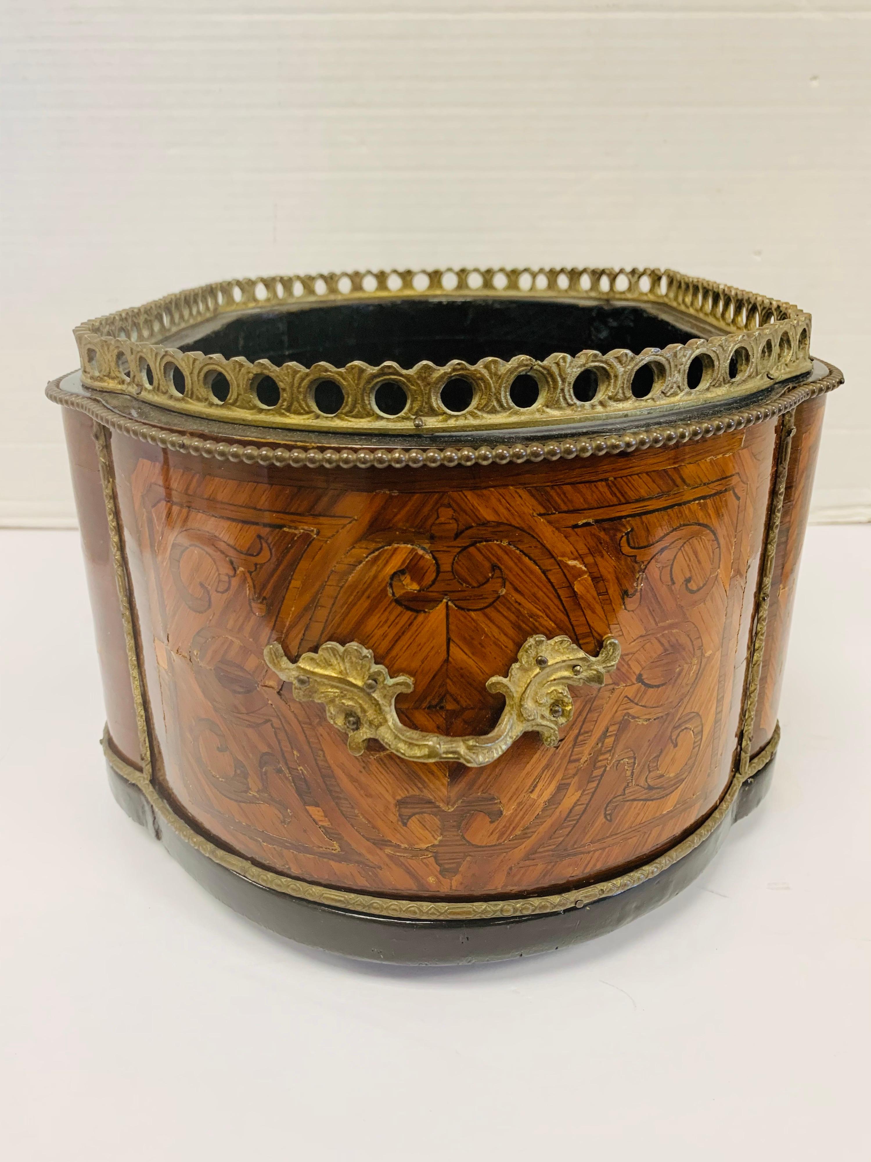 Exquisite mahogany and satinwood jardiniere with pierced brass gallery and beaded edge. Brass carrying handles on each side. Raised on bum feet.