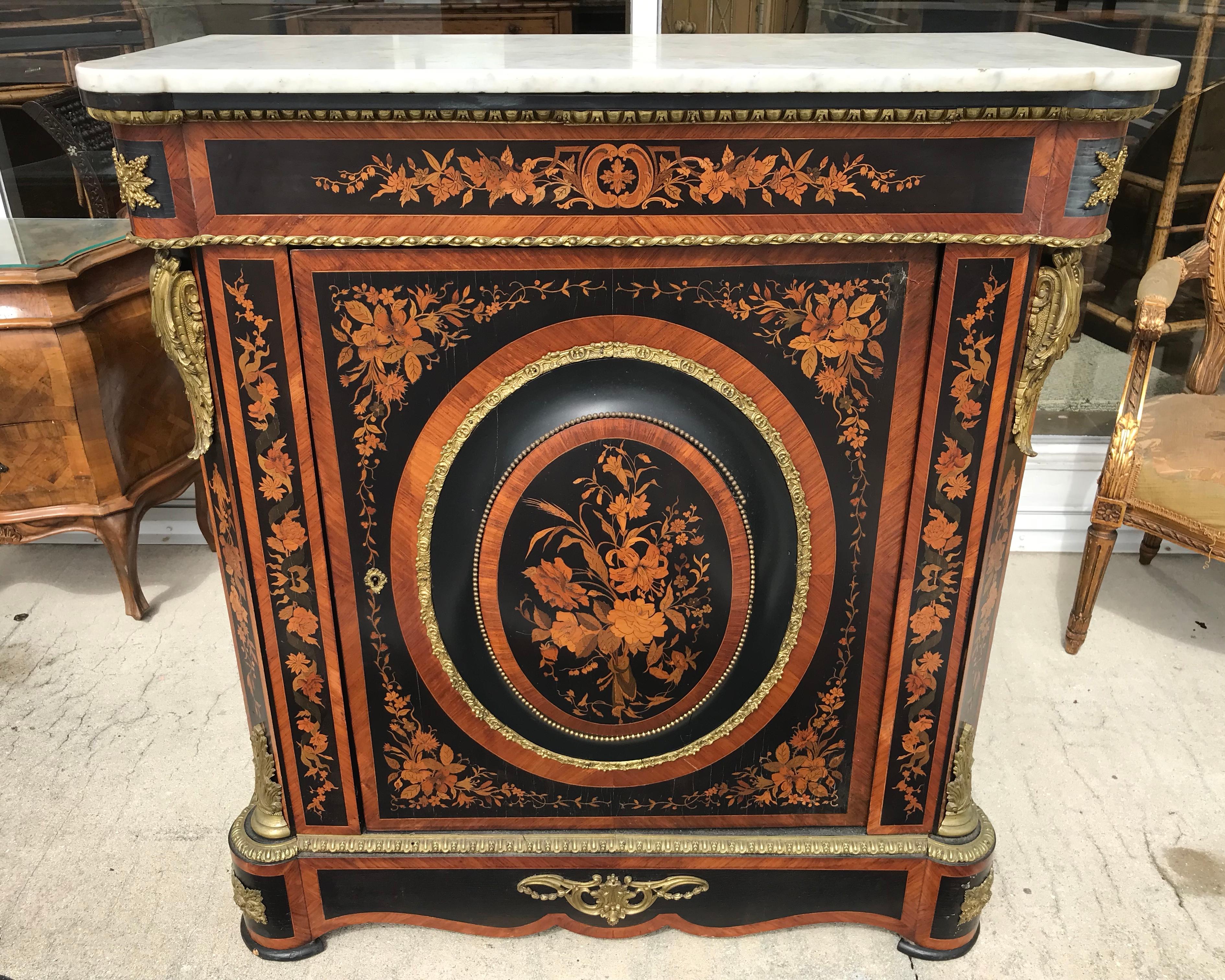 Fashioned with elaborate inlays and appointed with rich bronze adornments.
The cabinet is dramatic in scale and ornamentation.
The marble top is original, and the large central medallion is slightly convex - unusual.