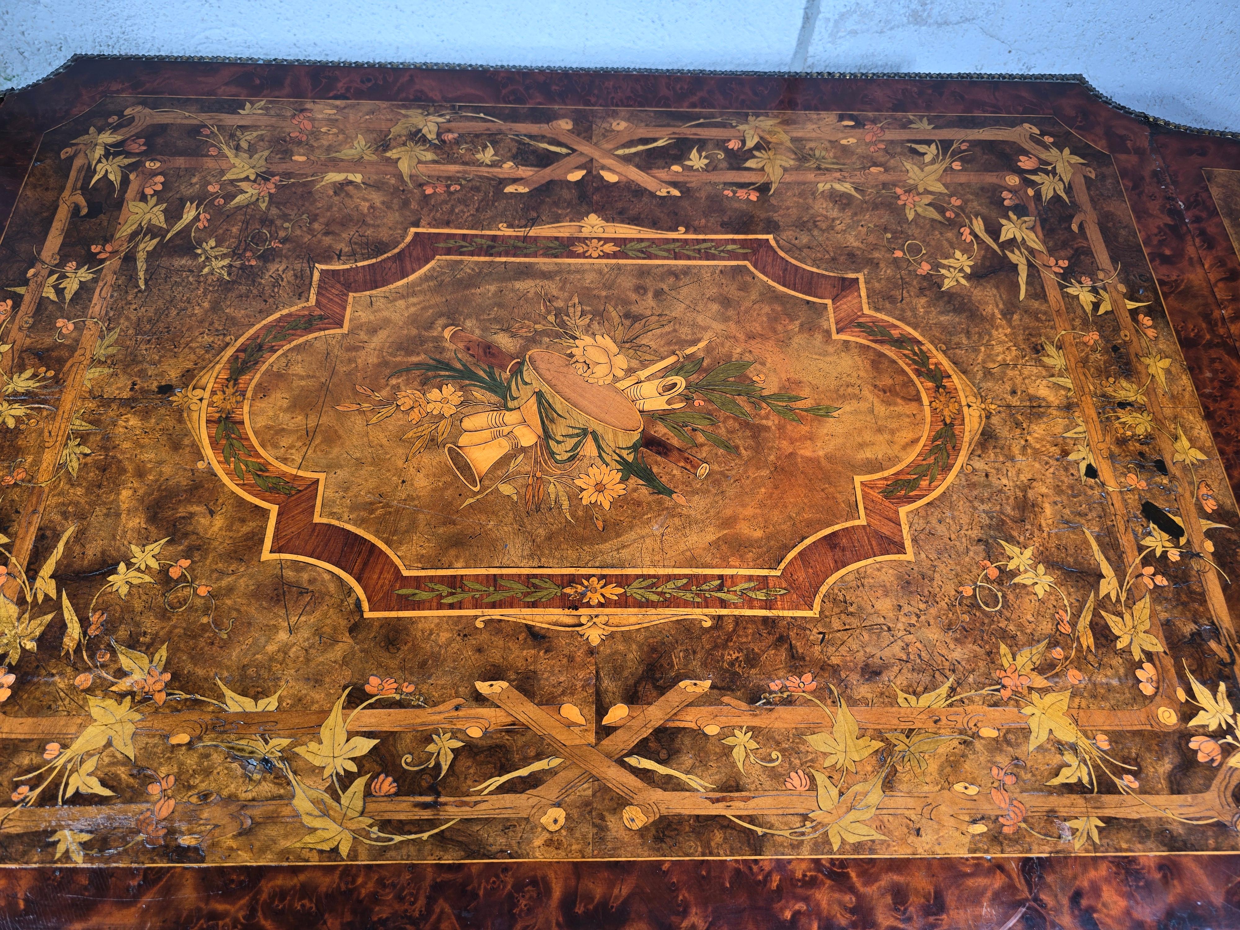 Questo elegante tavolo francese del XIX secolo è uno straordinario esempio di artigianato, caratterizzato da una squisita intarsiatura e ornato da accenti in bronzo cesellato. Gli intricati dettagli dell'intarsio evidenziano l'eccezionale abilità e