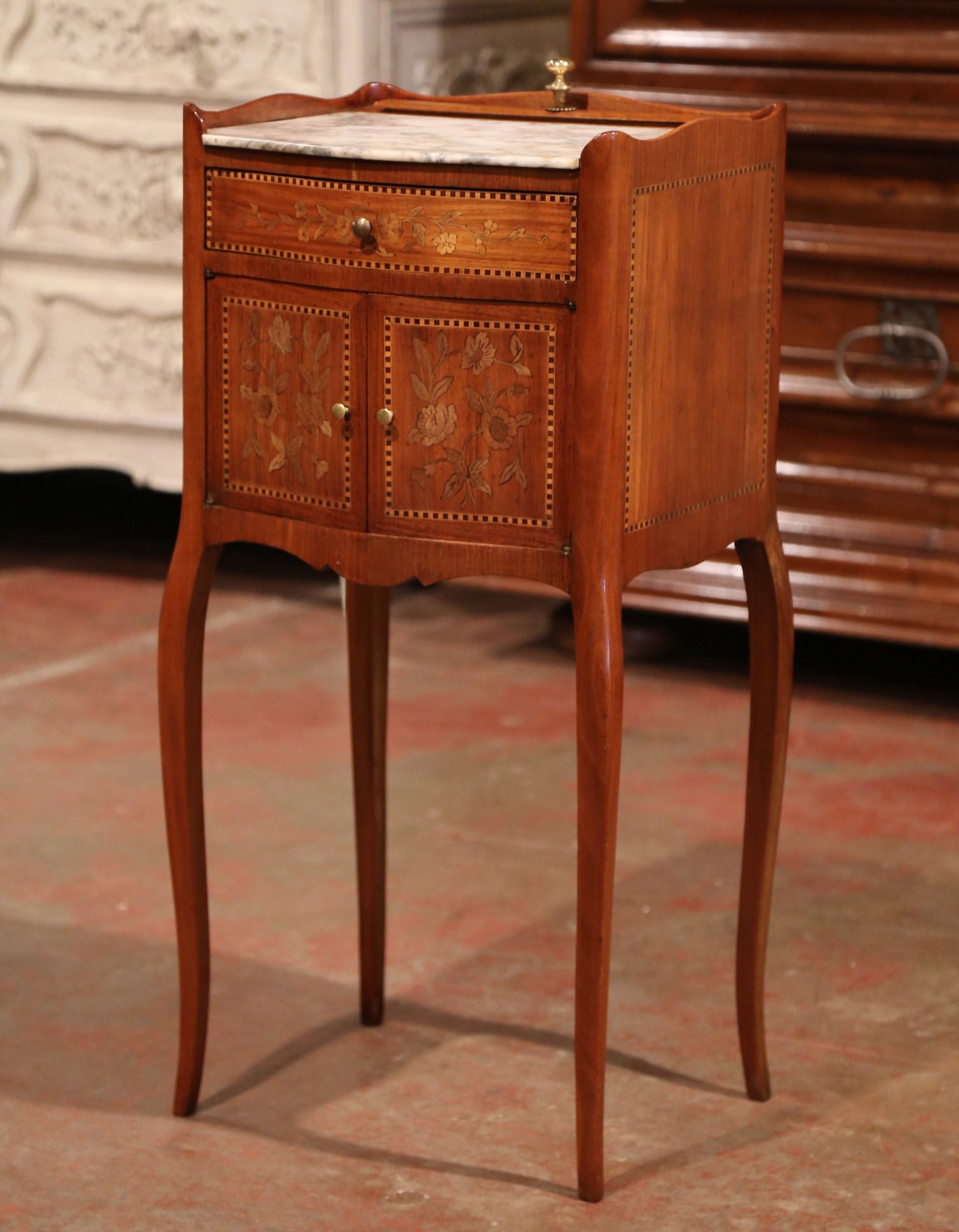 Decorate a powder room or a boudoir with this elegant antique fruitwood cabinet, crafted in France circa 1870, the Louis XV bedside table stands on cabriole legs over a scalloped apron. The bombe front with central drawer features two doors