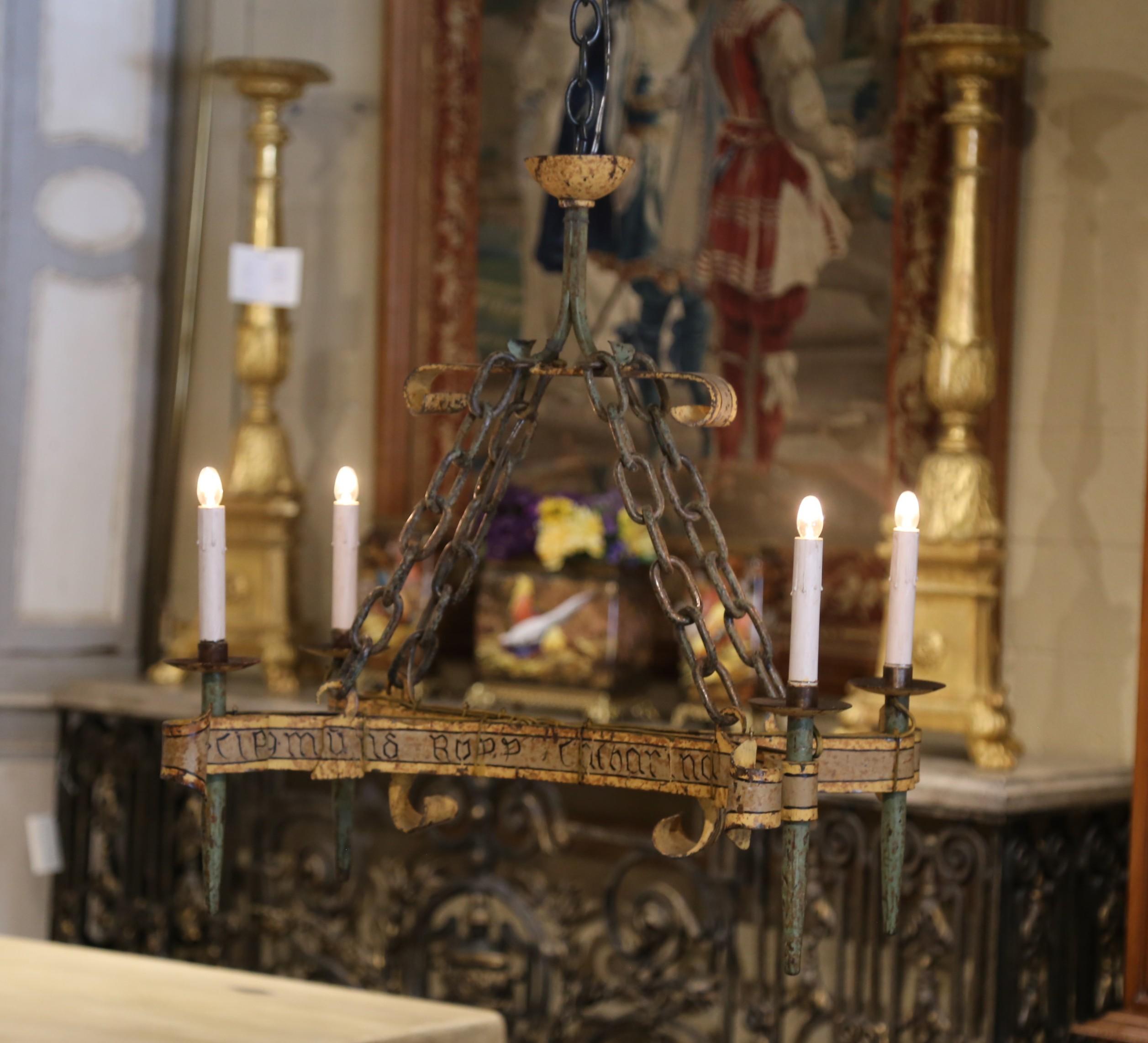Decorate a den or study with this interesting antique chandelier. Crafted in France circa 1880, the medieval-style fixture is built of wrought iron and adorns a painted with an aged, rustic patina. The design is reminiscent of early European Gothic