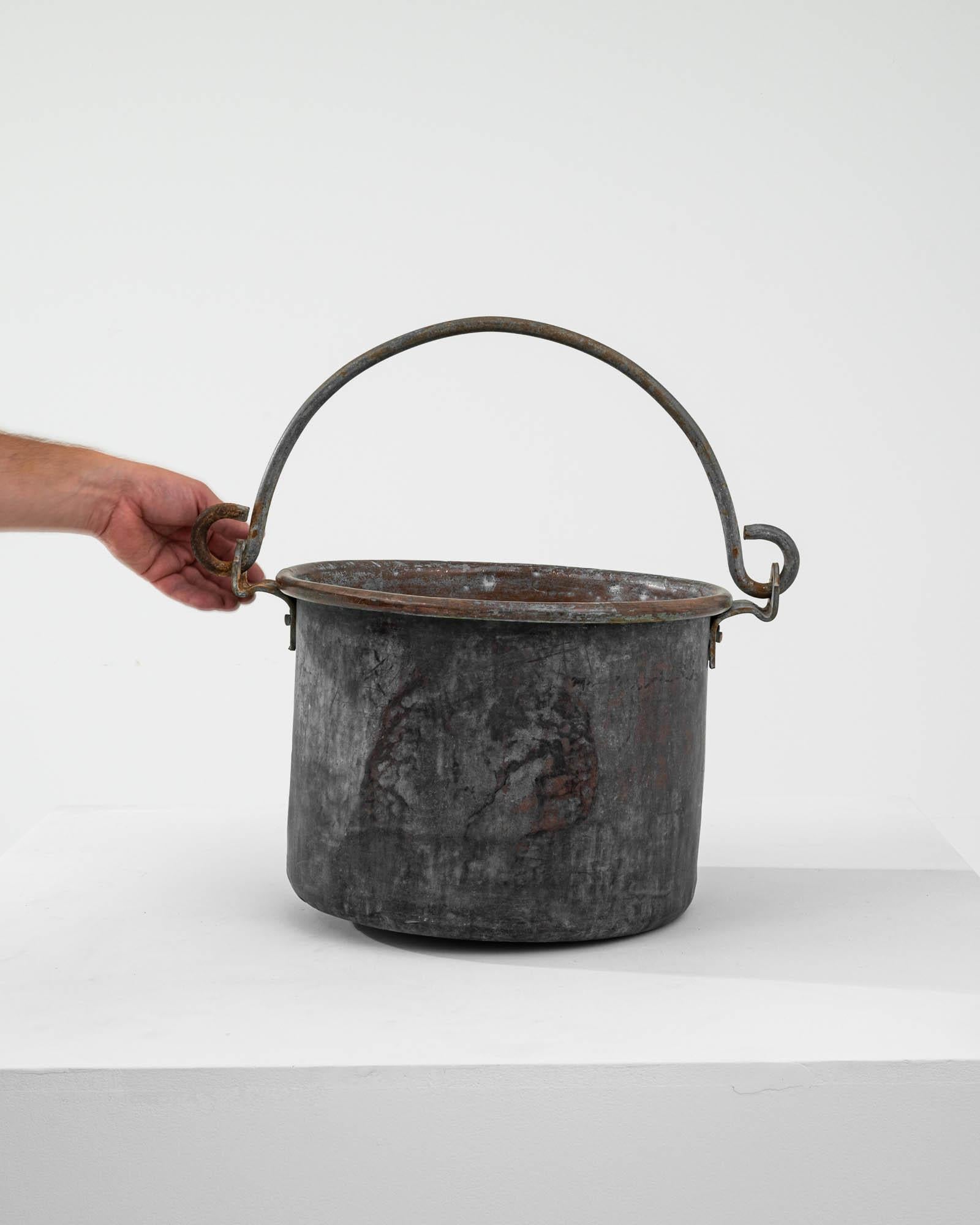 Fai un salto indietro nel tempo con questo autentico secchio di metallo francese del XIX secolo, una testimonianza dell'artigianato del passato. Questo pezzo robusto porta con sé il peso della storia, mostrando una patina splendidamente invecchiata