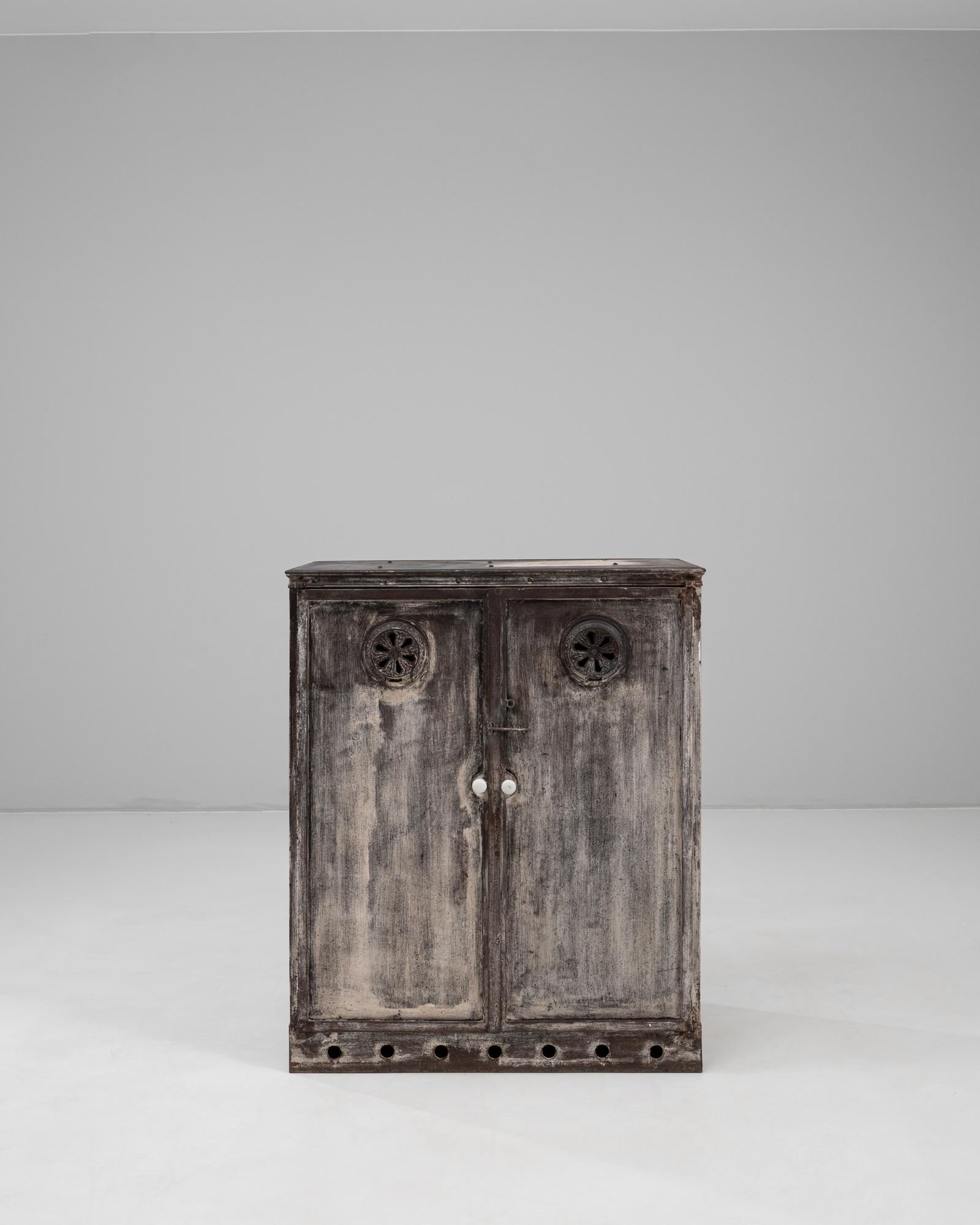 Questo buffet francese in metallo del XIX secolo incarna il fascino industriale e l'artigianato utilitaristico della fine del 1800. Costruito interamente in metallo, il pezzo presenta doppie porte con aperture di ventilazione decorative e scaffali