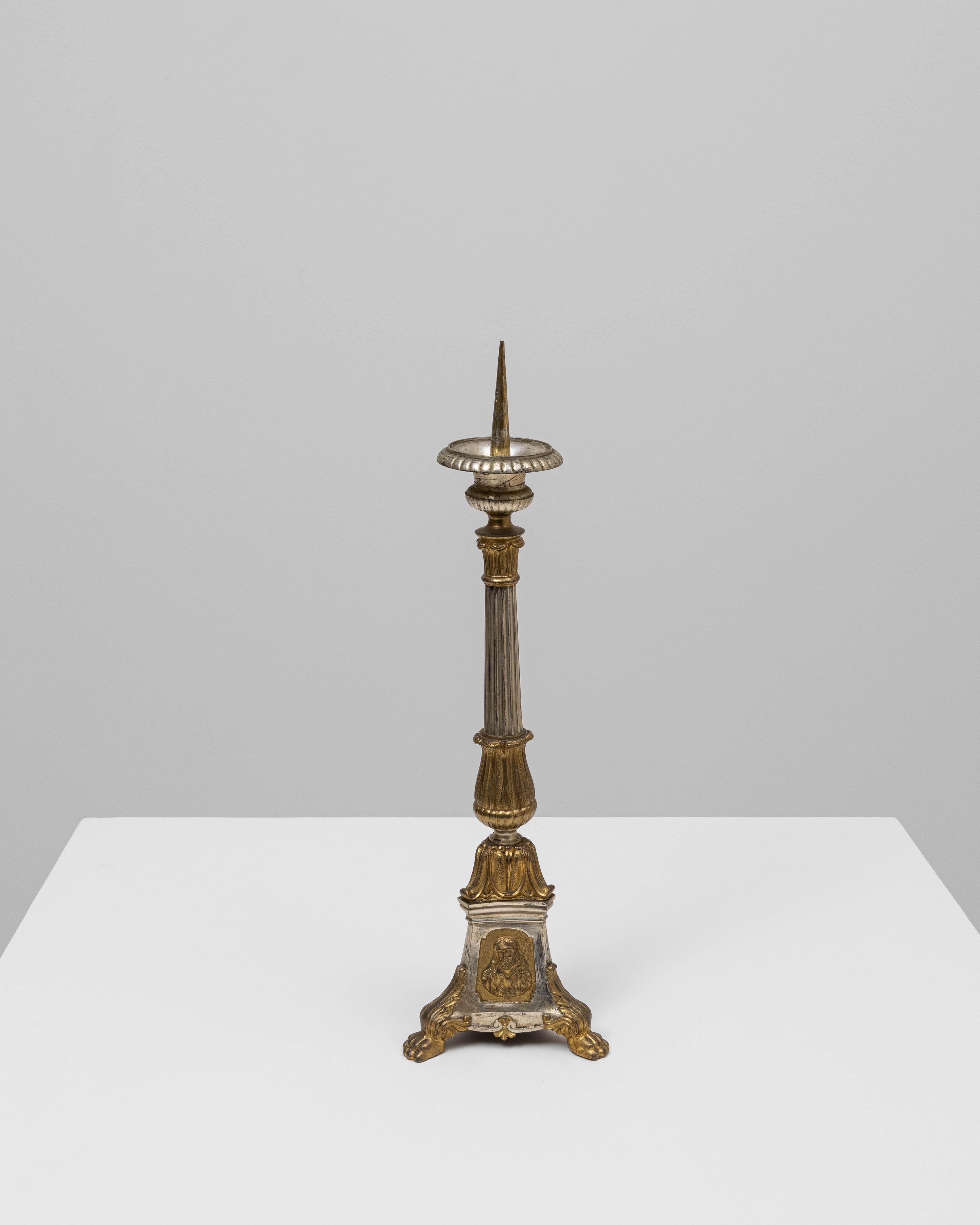 Questo candeliere francese in metallo del XIX secolo presenta una silhouette ricca di dettagli che riflette le tendenze decorative dell'epoca. La colonna centrale scanalata si trasforma in una sezione inferiore scolpita e ornata da motivi classici,