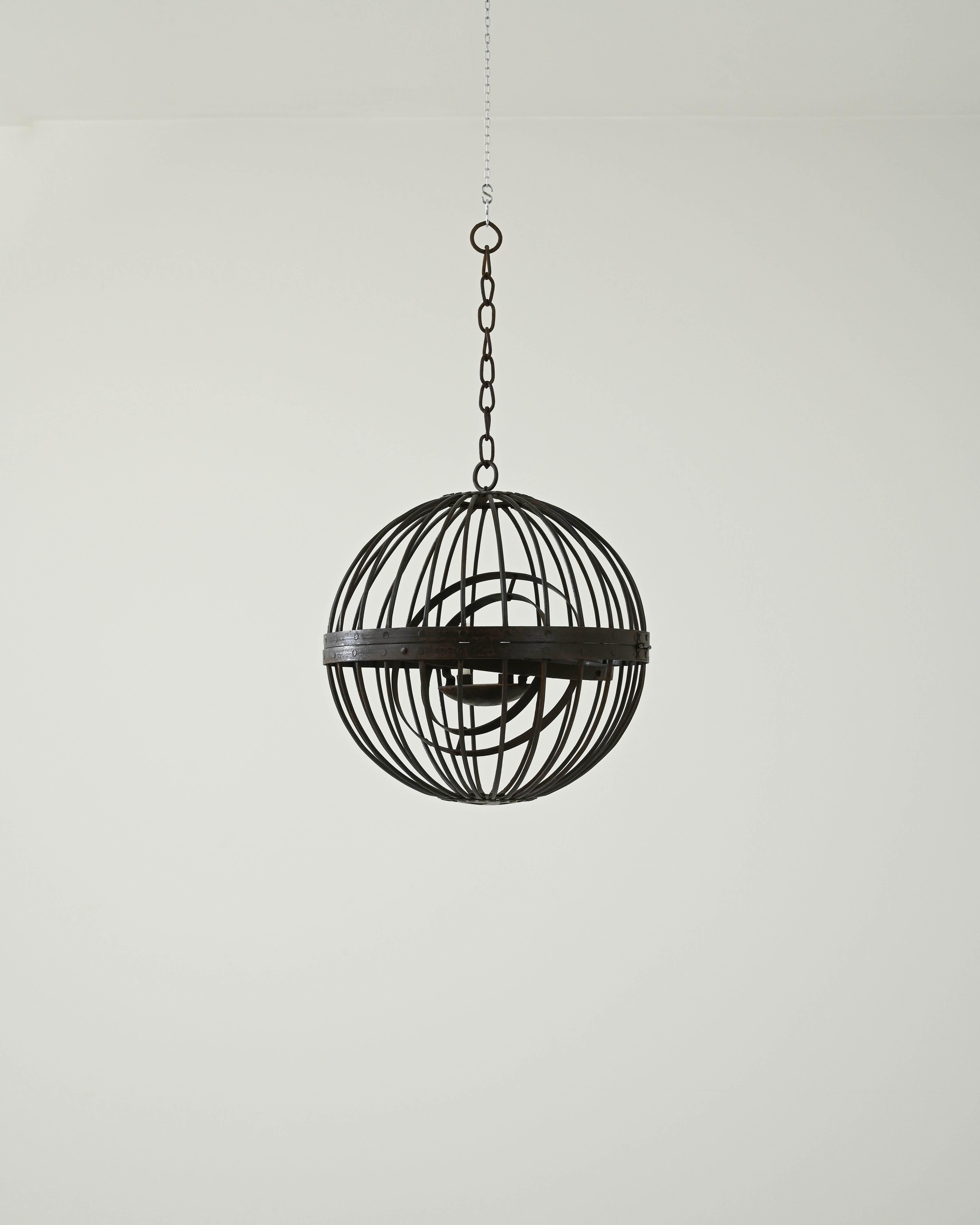A metal hanging candlestick fixture created in 19th century France. Brimming with neo-gothic inspired style, this spherical candlestick holder offers a traditional yet fresh look. The tilted circular rings set within the curved exterior bars and