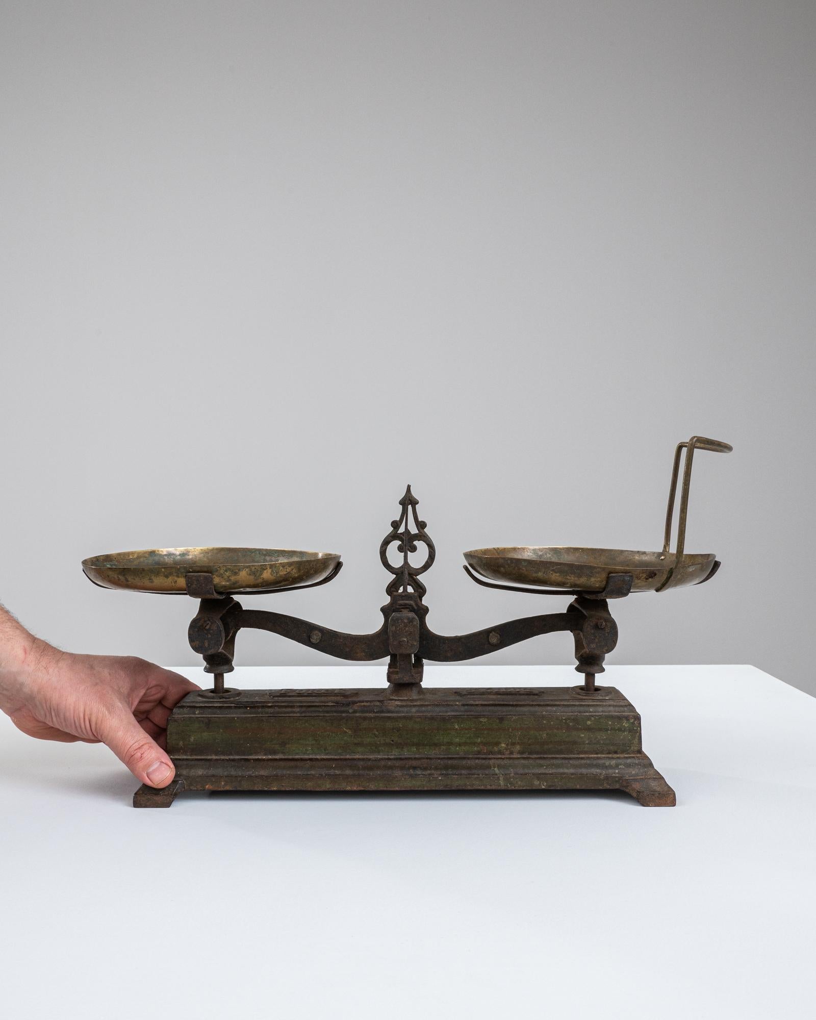 Step back in time with this authentic 19th Century French Metal Scale, a testament to the enduring quality and craftsmanship of a bygone era. With its ornate metalwork and robust brass pans, this scale is not just a measuring device but a piece of