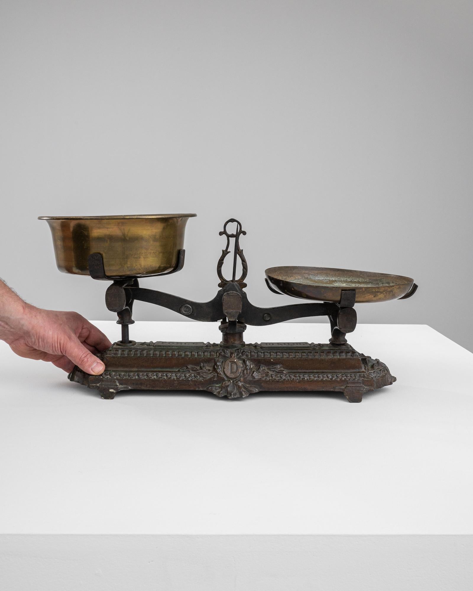 Step into the aura of 19th-century France with this majestic metal scale, a striking relic of its era. This vintage scale boasts a balance of brass and iron, featuring a lustrous brass bowl on one side, poised against a seasoned iron plate,