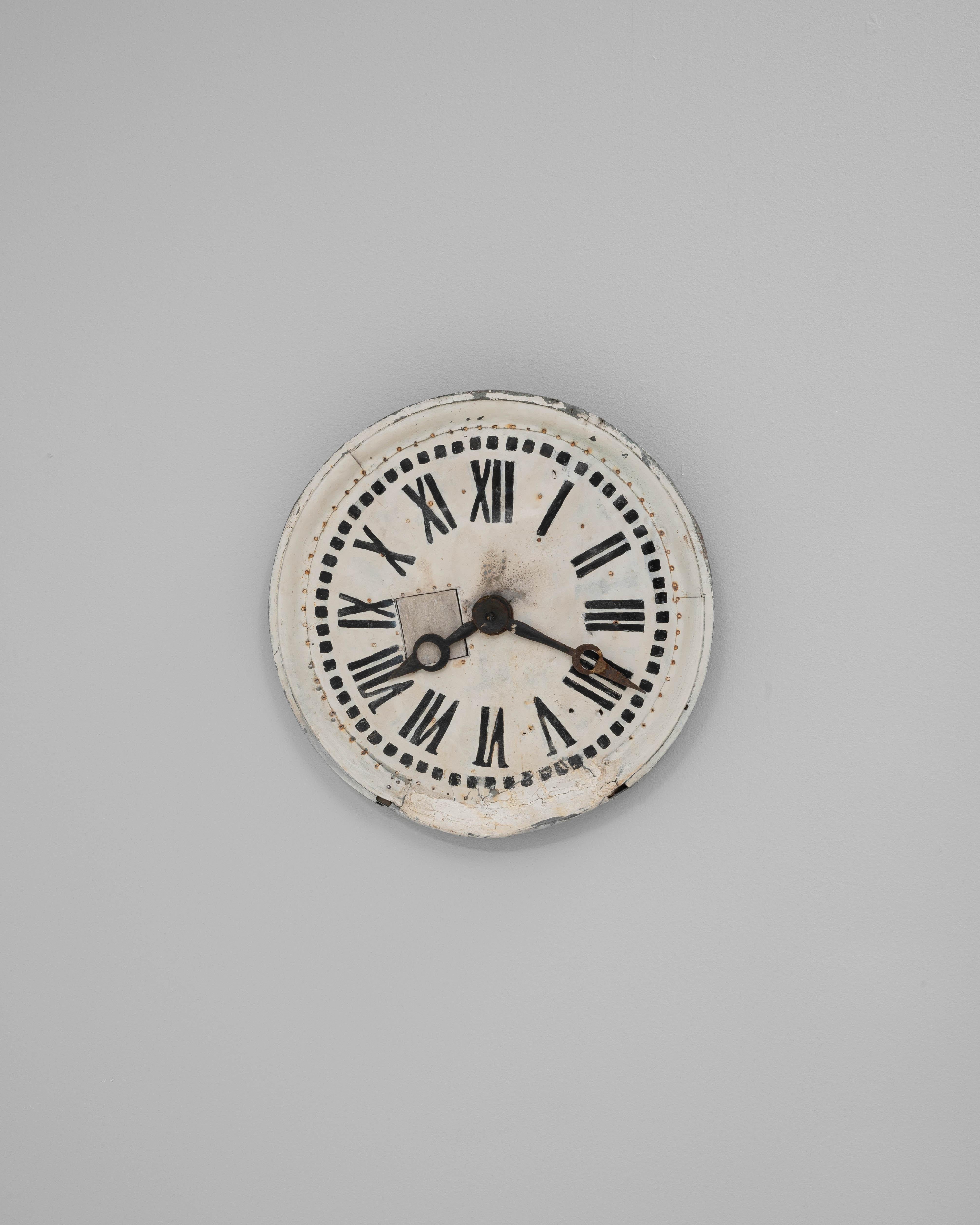 This 19th Century French wall clock features a striking combination of metal and wood, showcasing a weathered patina that tells the story of its age and use. The circular frame is crafted from wood with a distressed painted finish, while the face is
