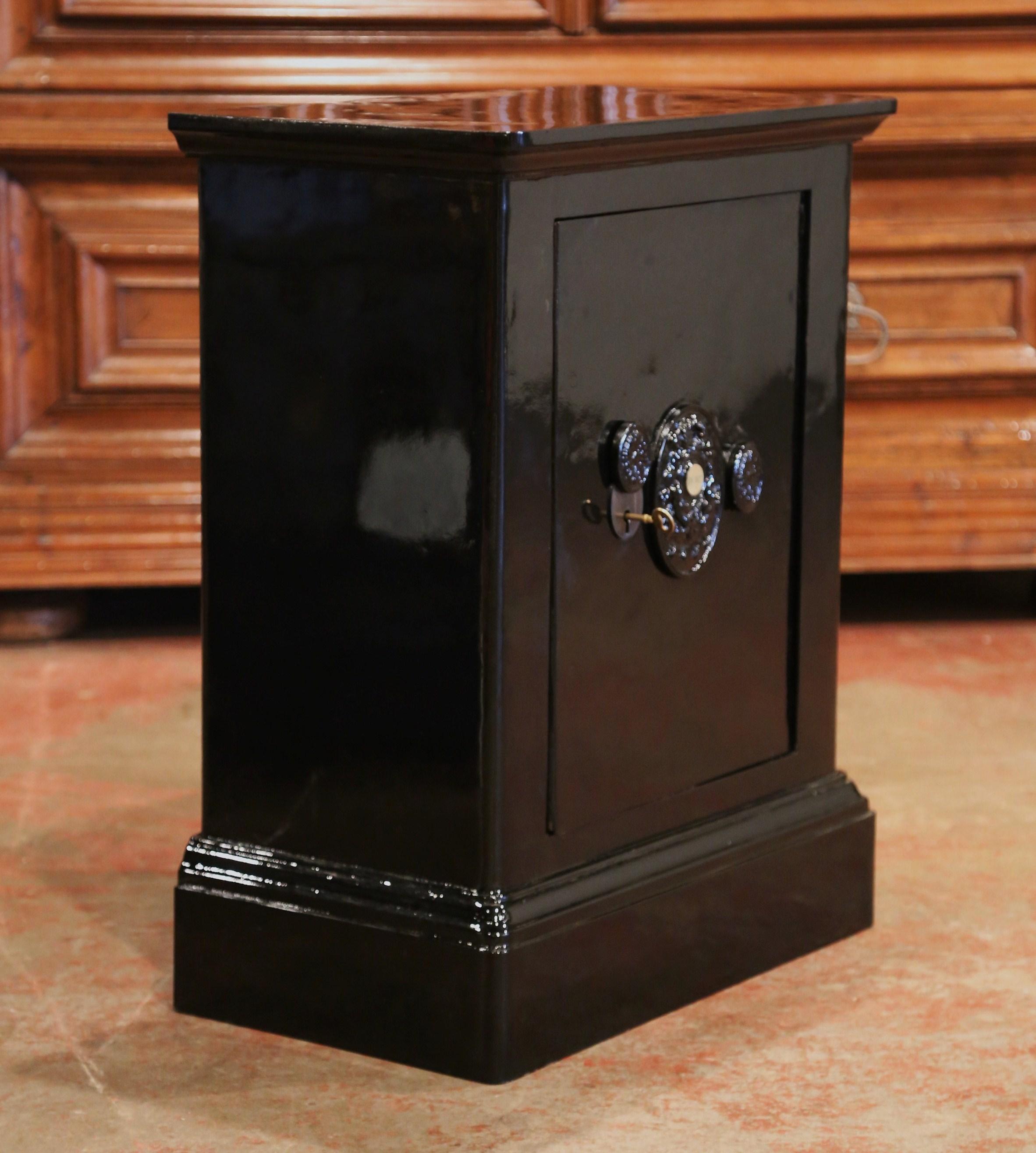 This antique iron safe, signed Fichet, was crafted in France, circa 1870. The heavy piece has been completely repainted with a black glossy, metallic paint. The door opens to reveal two inside shelves for storage. The important lock has an intricate