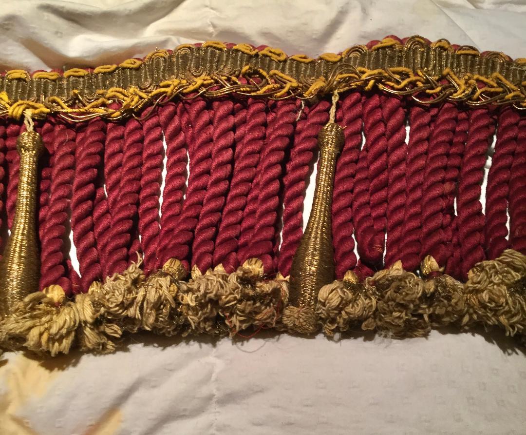 Rare 19th century French large piece of metallic trim with unusually large twisted rope trim with metallic threads on bottom of beige tassels. Large rope is a burgundy color.
The top trim is a bronze color with gold threads. Some of the gold trim