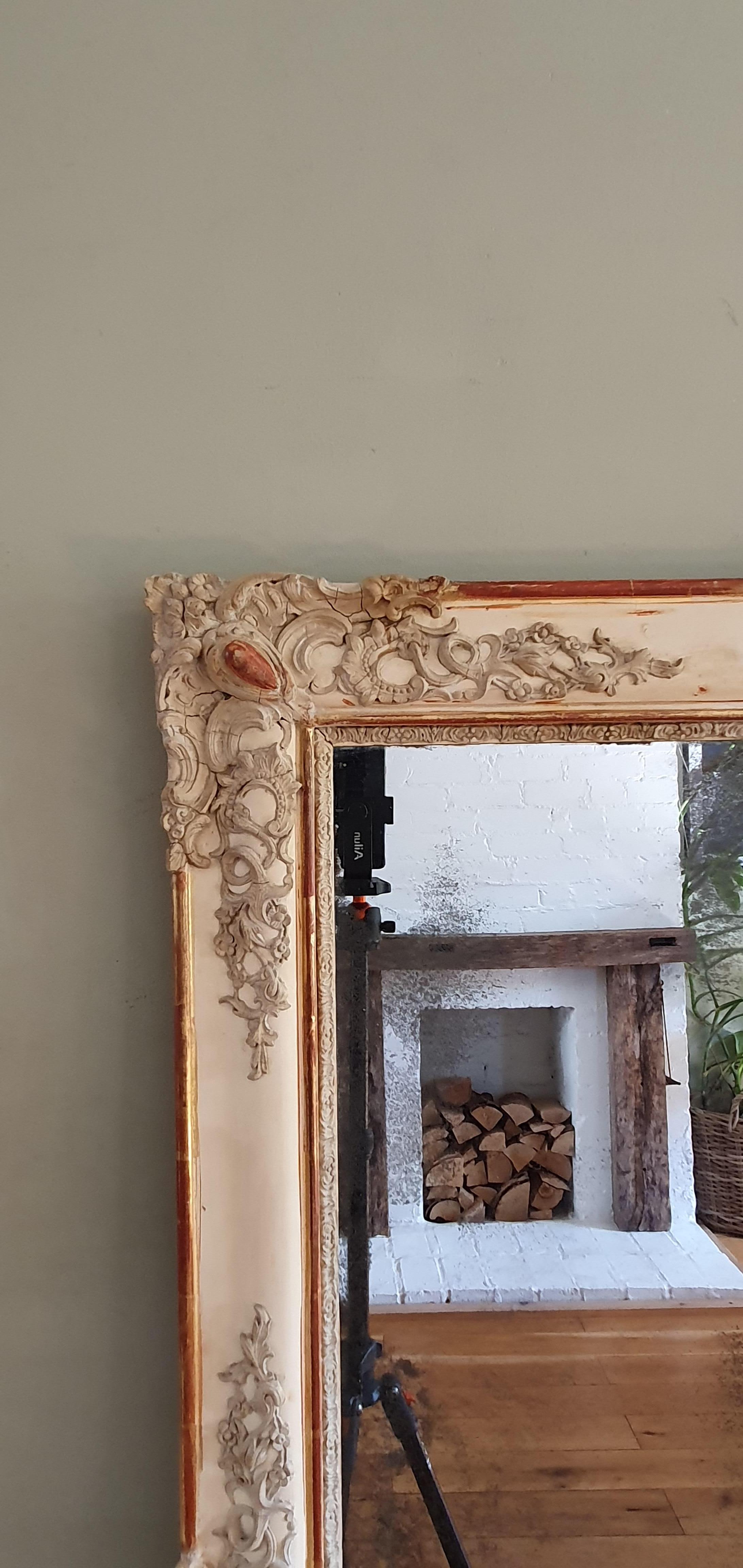 19th century French wall / mantel mirror. Distressed finish, some of original gilding remains, contains original mercury glass with signs of age (black spots, scratches etc). Very decorative with floral ornaments.