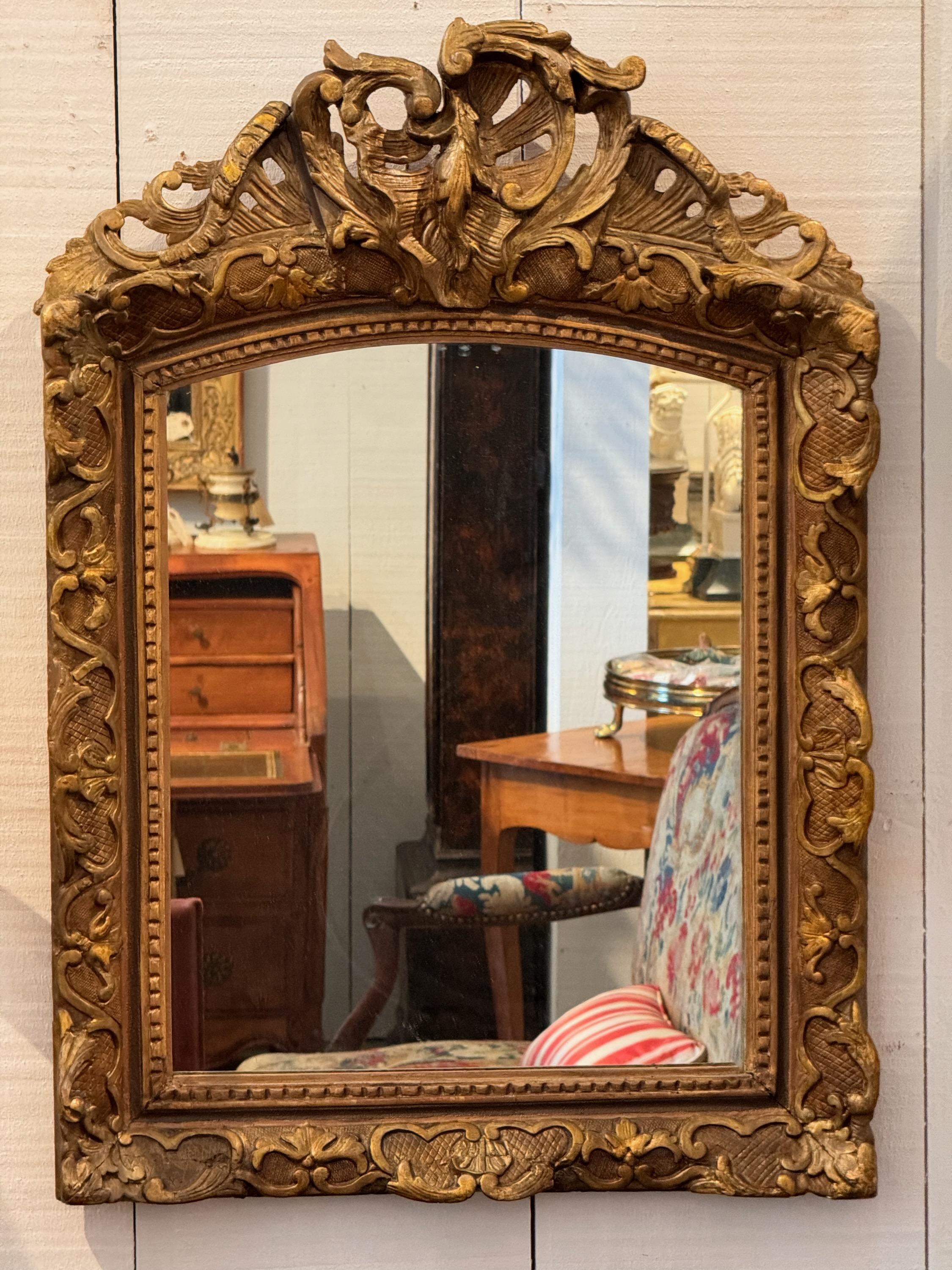 A heavily carved Giltwood mirror. In the Regence style.