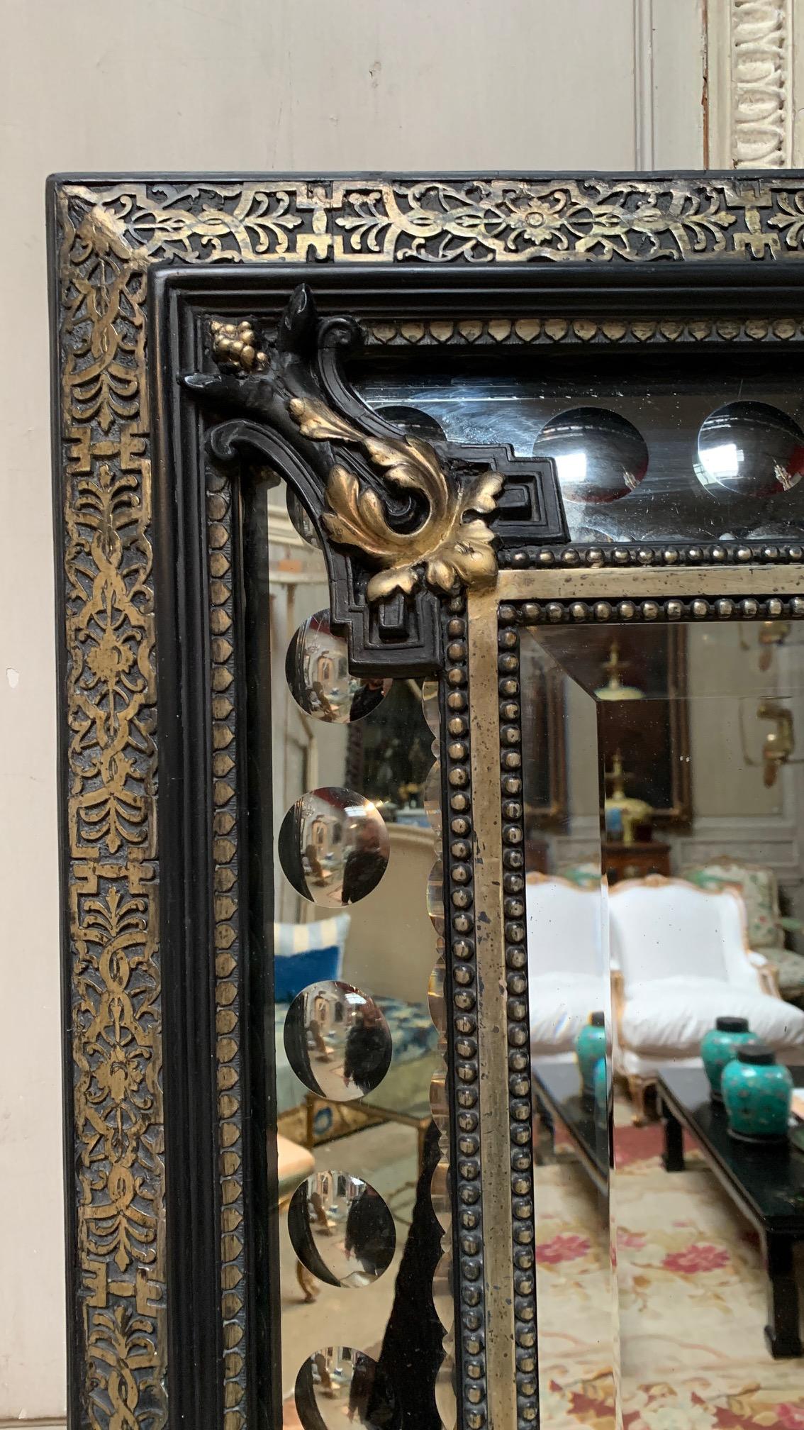 A French Napoleon III mirror with an ebonized finish an old silvered bronze detailing and moldings. A perfect mirror for an elegant powder room.