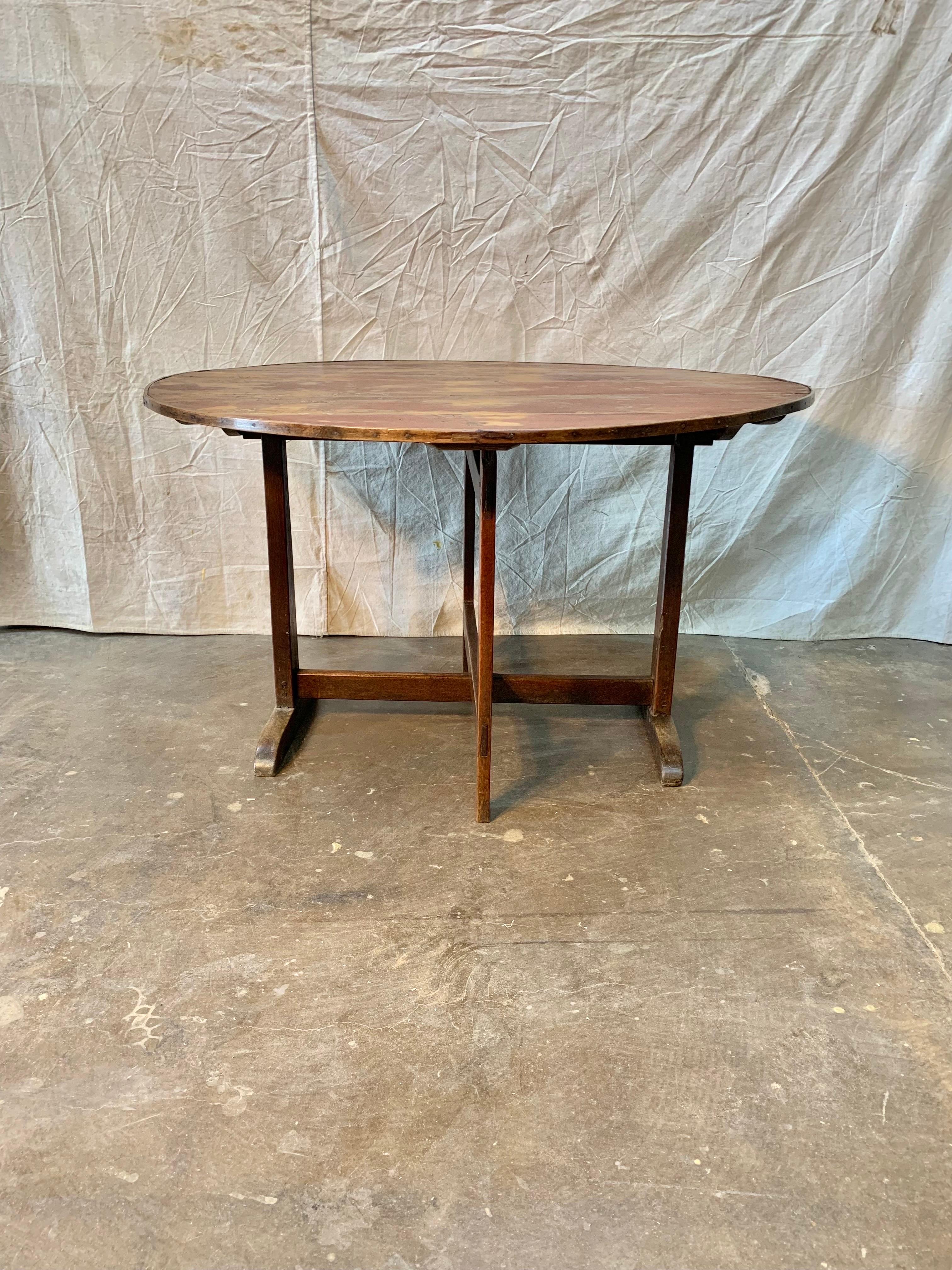 19th Century French wine tasting table, also known as a vendage or vigeron table, which was once used in the vineyards of France for tasting wine or enjoying a meal. This table would be suitable for use as a center table or in a wine cellar. The top