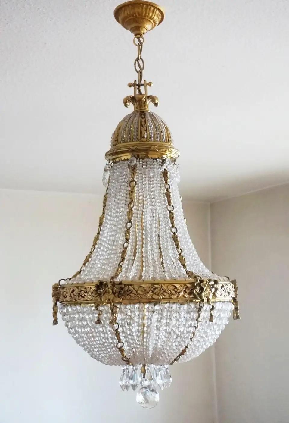 A wonderful Empire style bronze parcel brass crystal beaded chandelier, France mid-19th century. Beads, drops, and bottom ball are of genuine crystal, solid bronze and brass richly elaborate in precise detail, decorated with fine brass chains in