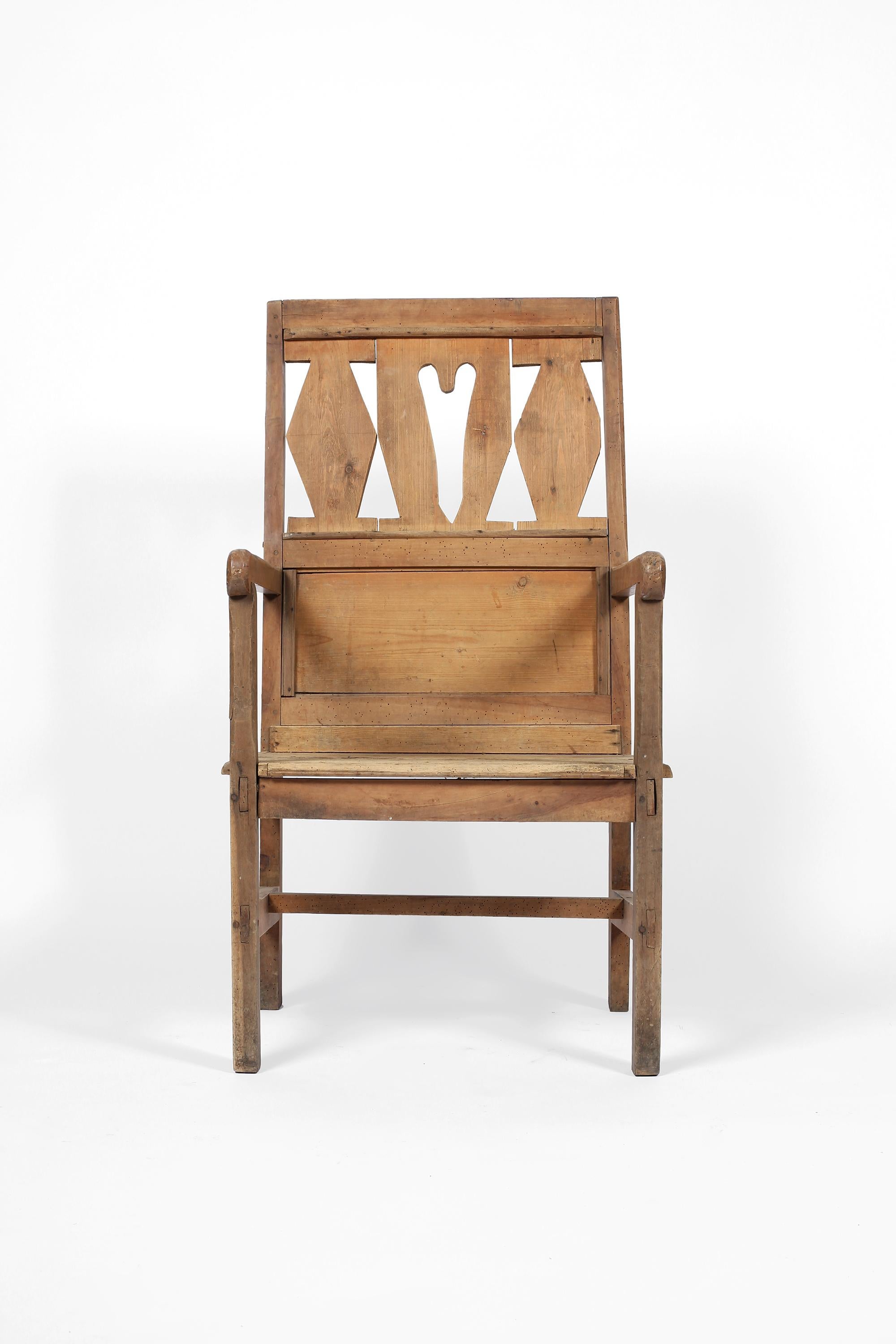 A charming late 19th century pine occasional armchair from the Alps region. Likely estate made with naive fretwork detailing to the tall, throne-like back rest. French, circa 1880.