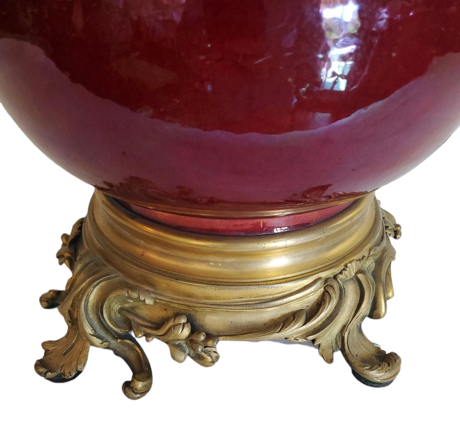 Very fine 19th century Chinese ox blood porcelain vessel converted to lamp with the finest 19th century French bronze mounts. Custom silk shade with metallic details. Shade is 15