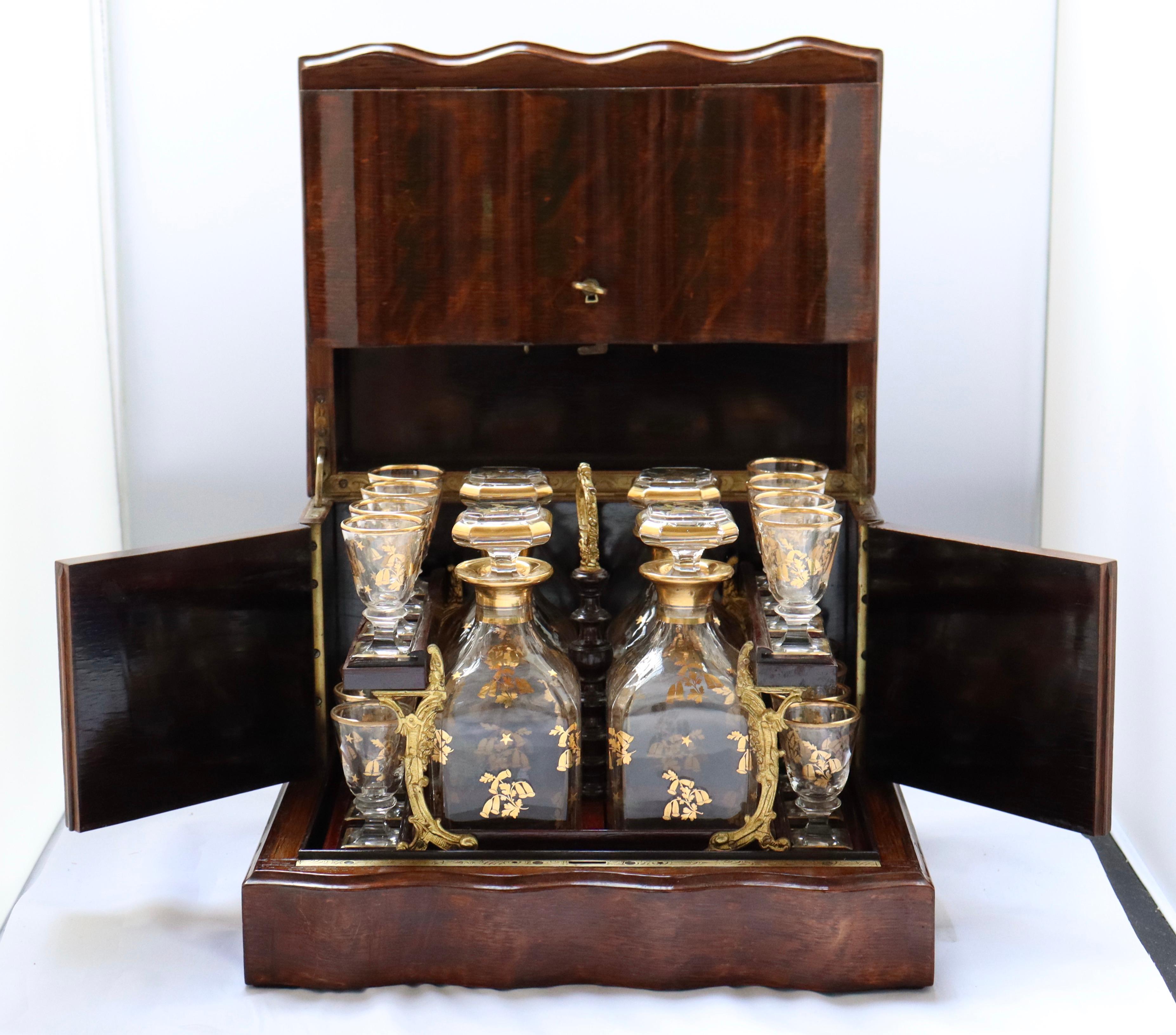 Comprising four Baccarat crystal decanter with stoppers and sixteen matching glass heightened with hand-painted gilding.
As with most caves a liqueur, when the front side is lifted, it folds into itself. The front and the three-quarter doors on each