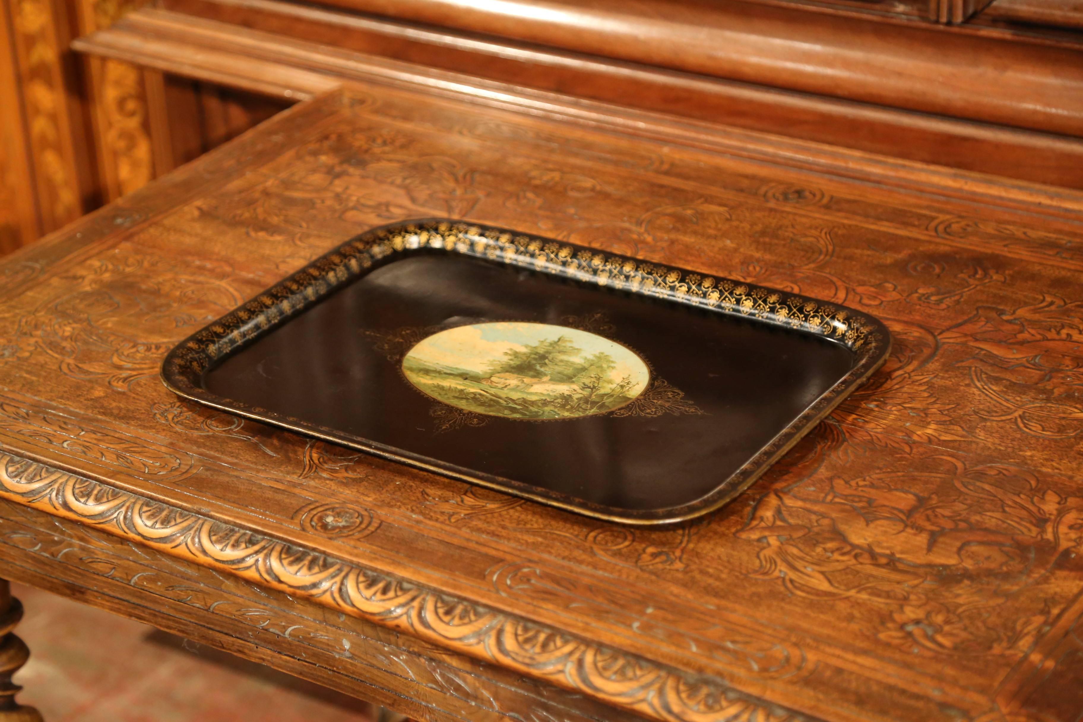 This elegant antique tray was created in France, circa 1870, rectangular in shape, the black tole platter is embellished by hand painted gilt decor around the lip, and features a colorful oval pastoral scene medallion in the center. The peaceful