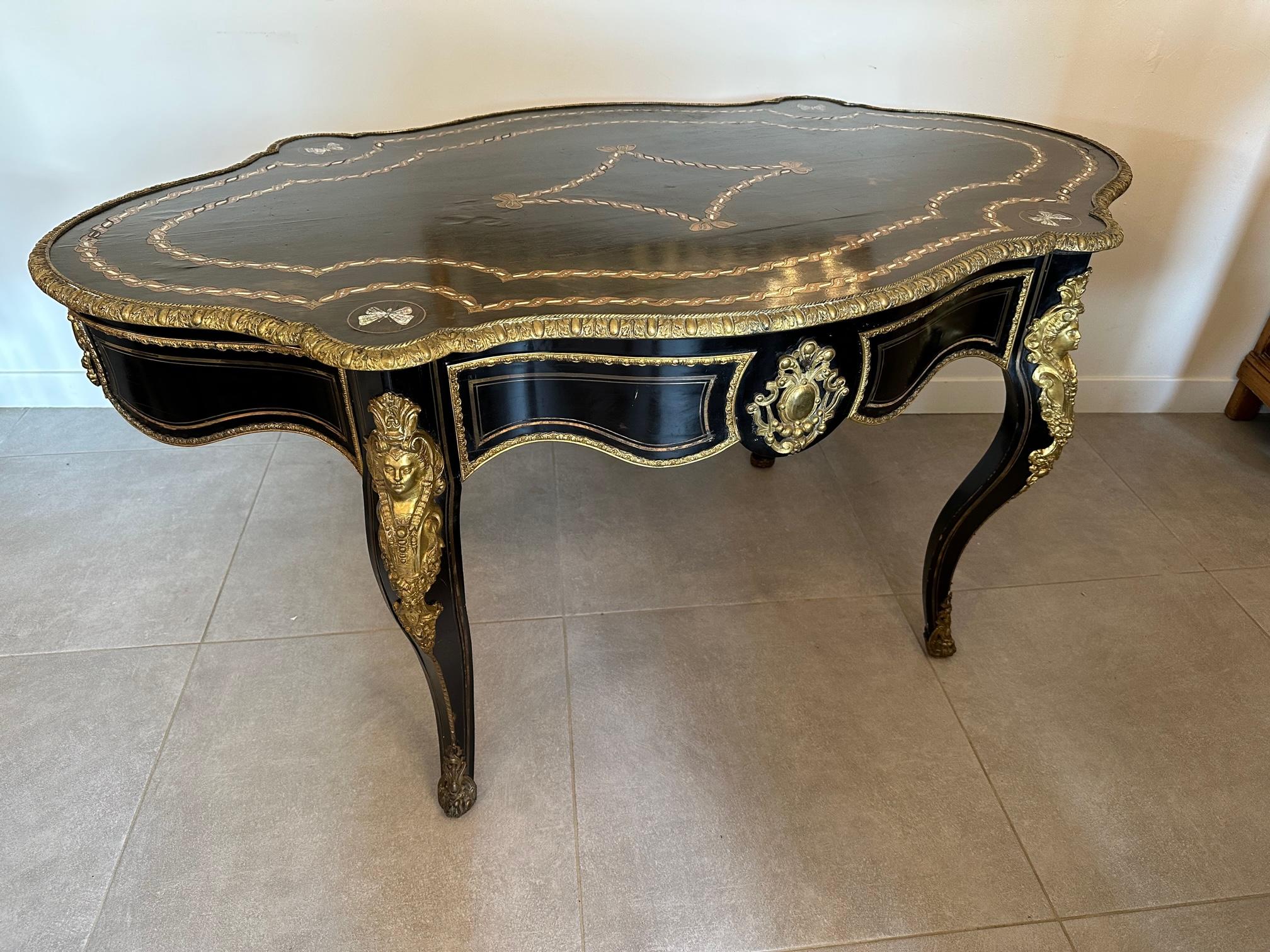 Very beautiful Napoleon III desk in blackened pear wood and bronze inlay. Encrusted mother-of-pearl butterflies. Bronze fitting representing caryatids.
Large central drawer. A few places to restore (see detailed photos) magnificent quality, rare