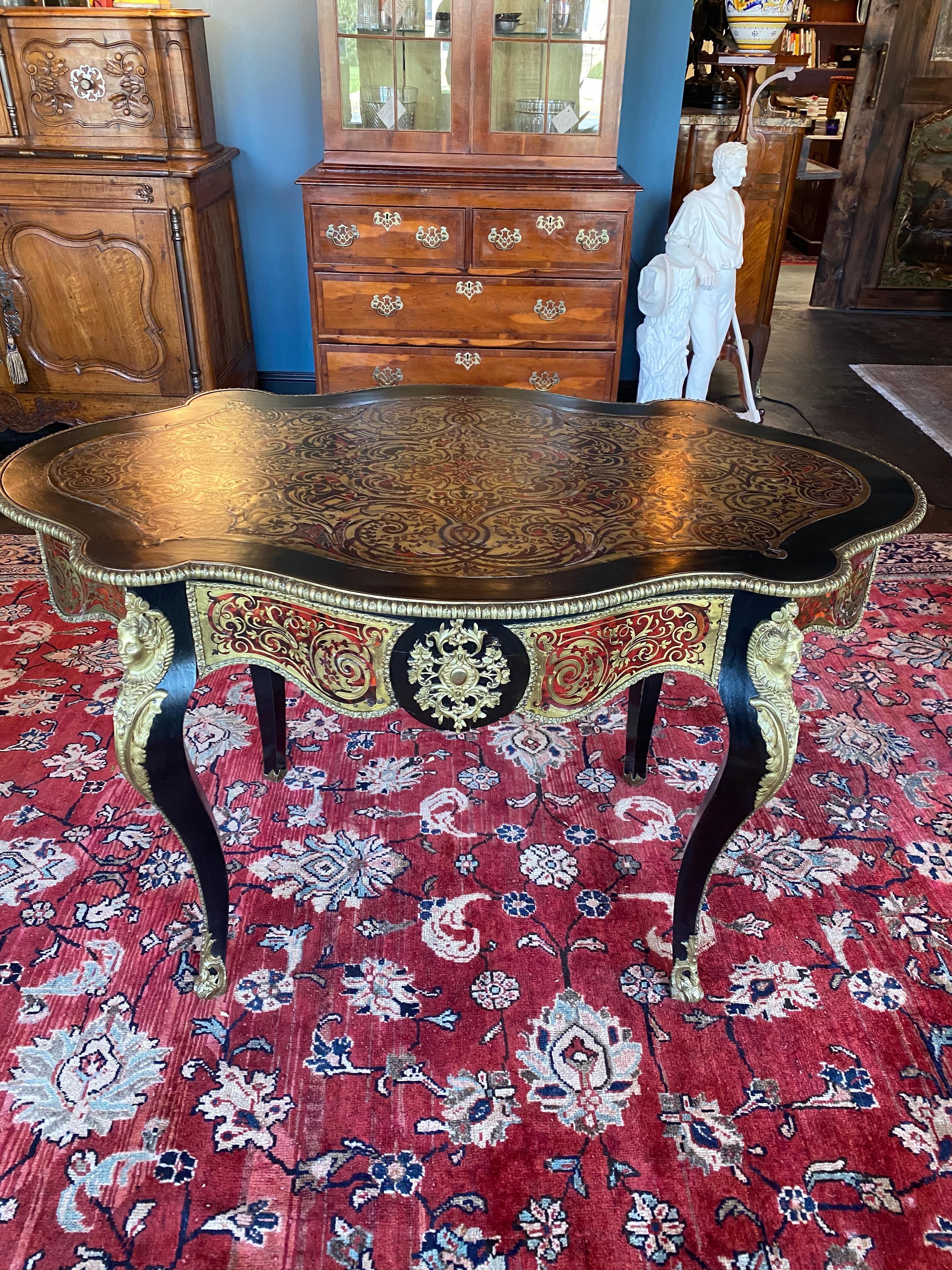 Good condition Ebonized Napoleon III Bedel & Cie Parisian made Boulle style centre table. One centre drawer, four cabriolet legs. The table is heavily decorated with bronze sabots, knee mounts and edge banding throughout. The top is brass and