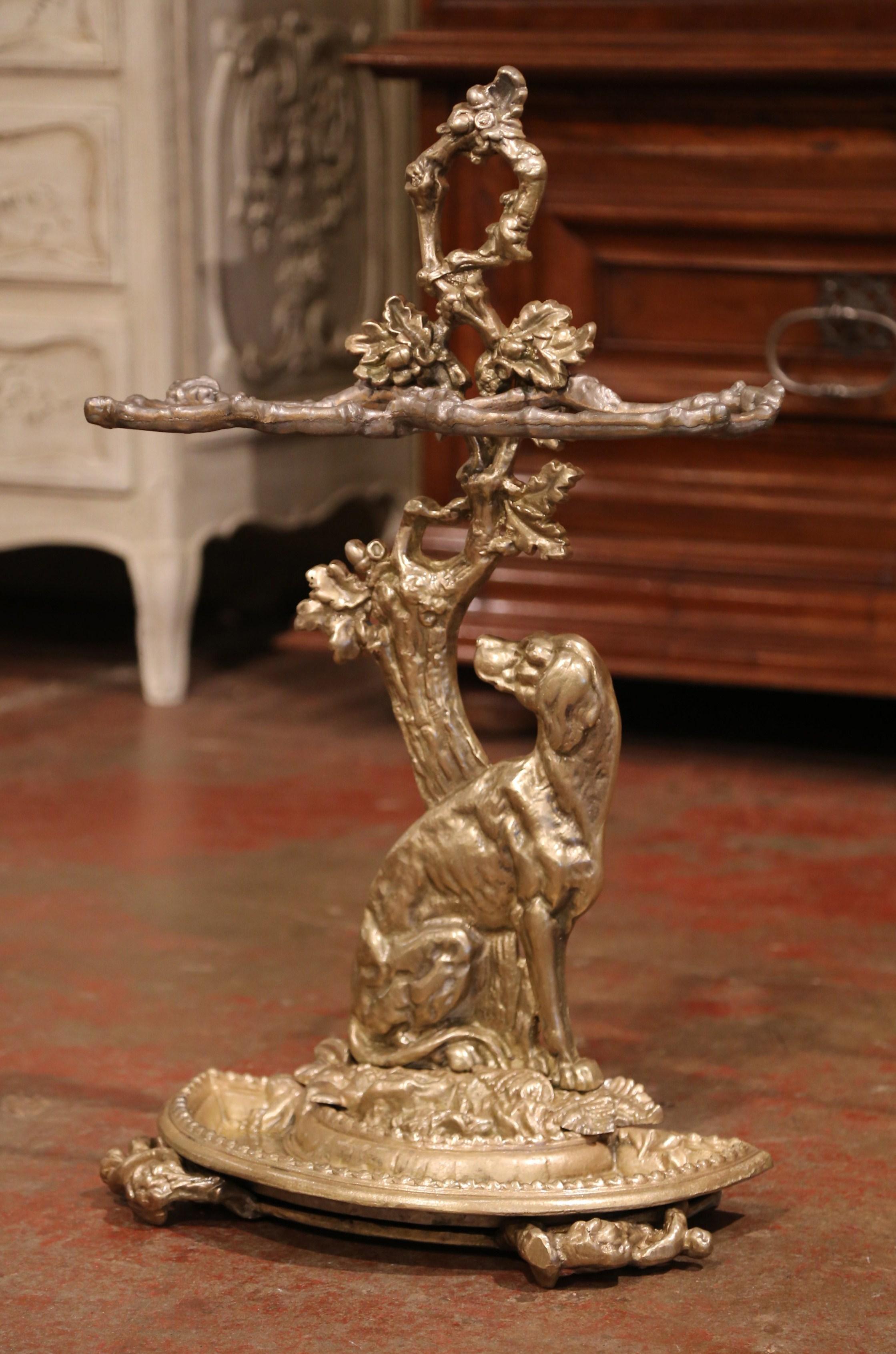 Decorate an entry with this elegant antique umbrella or cane stand; crafted in France, circa 1870, the freestanding stand features a hunt dog figure leaning against a tree decorated with foliage at the base. The stand sits on four small feet shaped